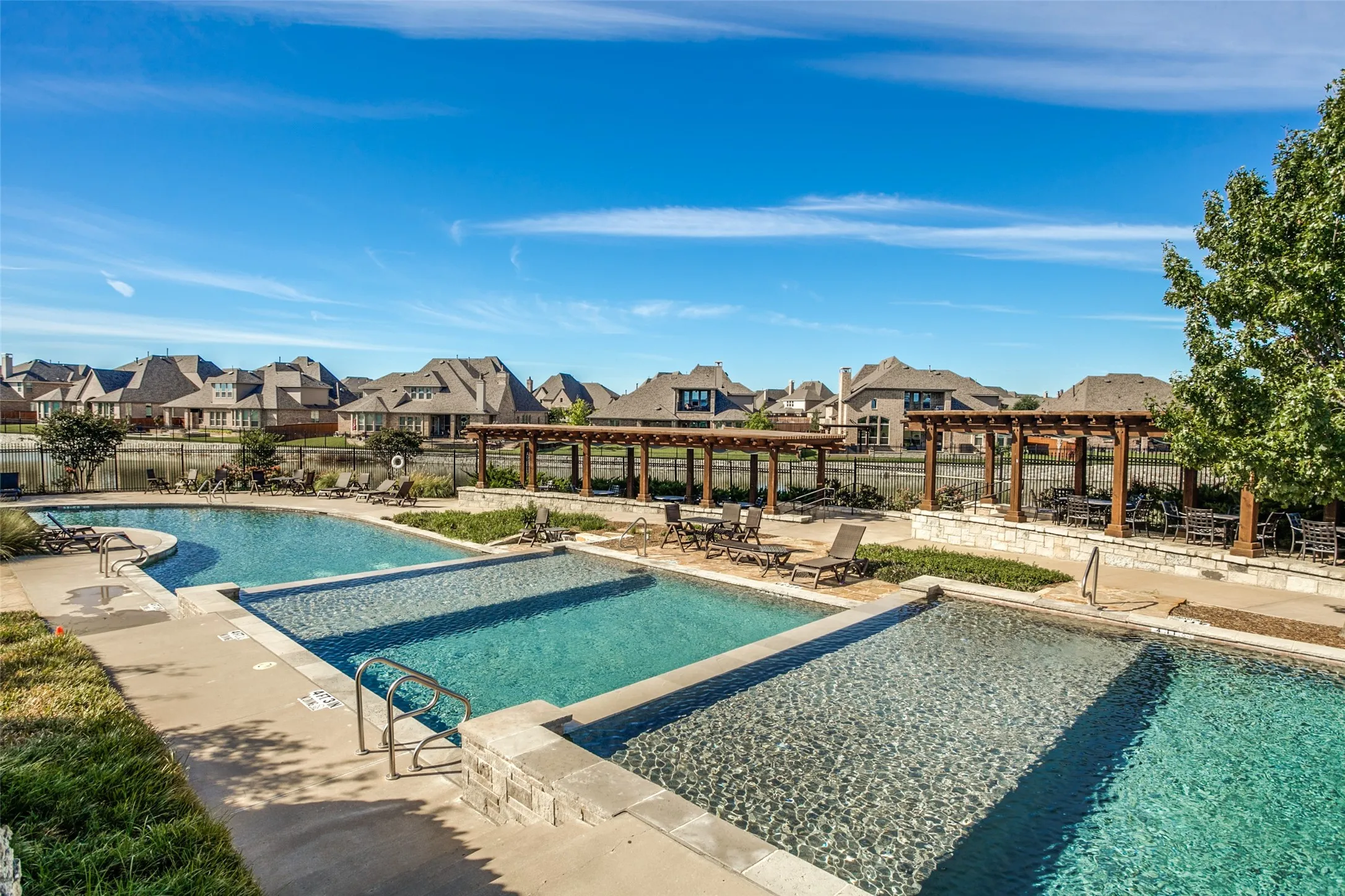 In The Tribute, you are never far from water!  Whether it is the lake surrounding the peninsula, canals in the community or one of several pool areas, there is always a nice water view or a fun place to jump in and get wet.  The resort-style pool is designed in levels for soaking or floating in three different sections.  Shady pergola provide tables and chairr and sunny lounge chairs surround the pool.