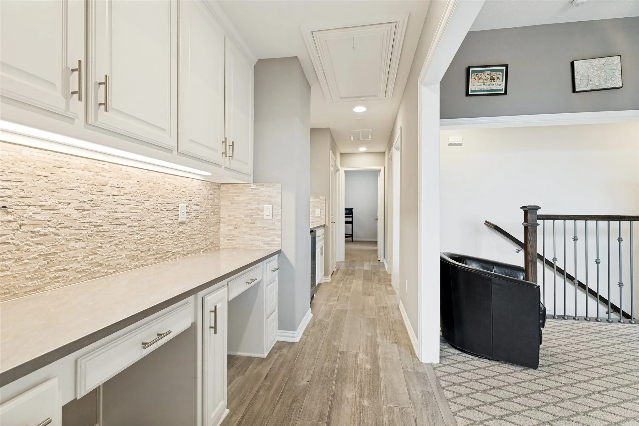 This upstairs built-in work center is a real plus.  Whether a homework nook, hobby space or gift wrapping station, it will definitely be useful.  Beyond is a refreshment bar with a fridge - great for family or guests.  The tile with a wood floor look is the ideal flooring for this more heavily trafficked area.  Recessed lights area at the ceiling along with a pull-down stair for attic access.