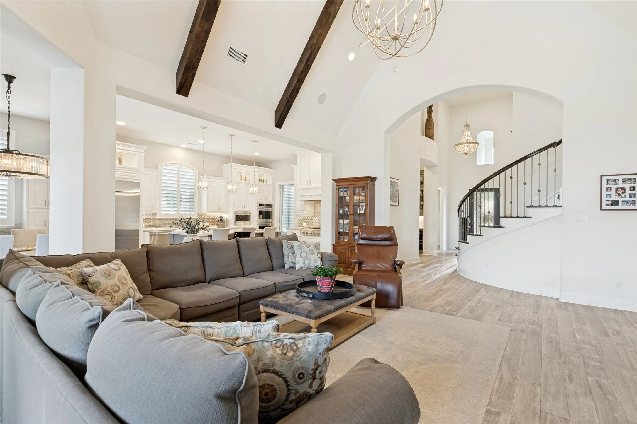 Family and guests alike will enjoy the spacious open area that is the heart of the home.  The height of the cathedral ceiling is emphasized by a pair of matching beams.  Speakers and recessed lights are at the ceiling along with an attractive hanging chandelier.