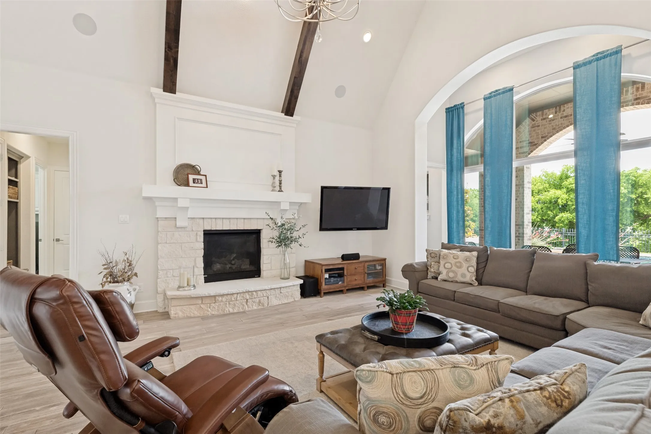 The focal point in the family room is the impressive fireplace.  Creamy stone forms the lower part and includes a hearth, while handsome millwork creates a distinctive mantle and upper level.  To the right, there is a sizable space for a piece of furniture or today's size TV.