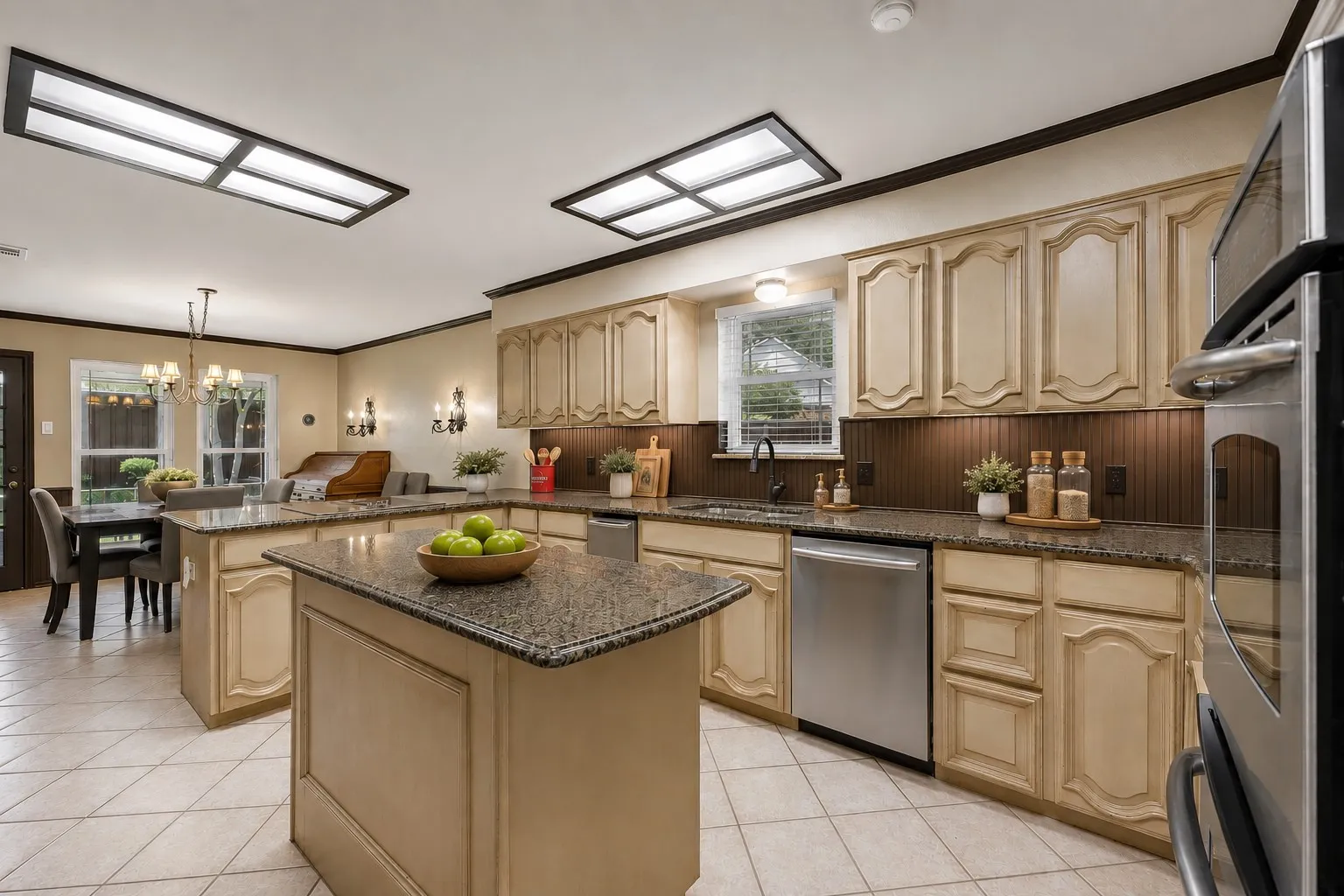 Kitchen featuring dual islands with stone countertops, a stainless steel dishwasher, and built-in wall oven