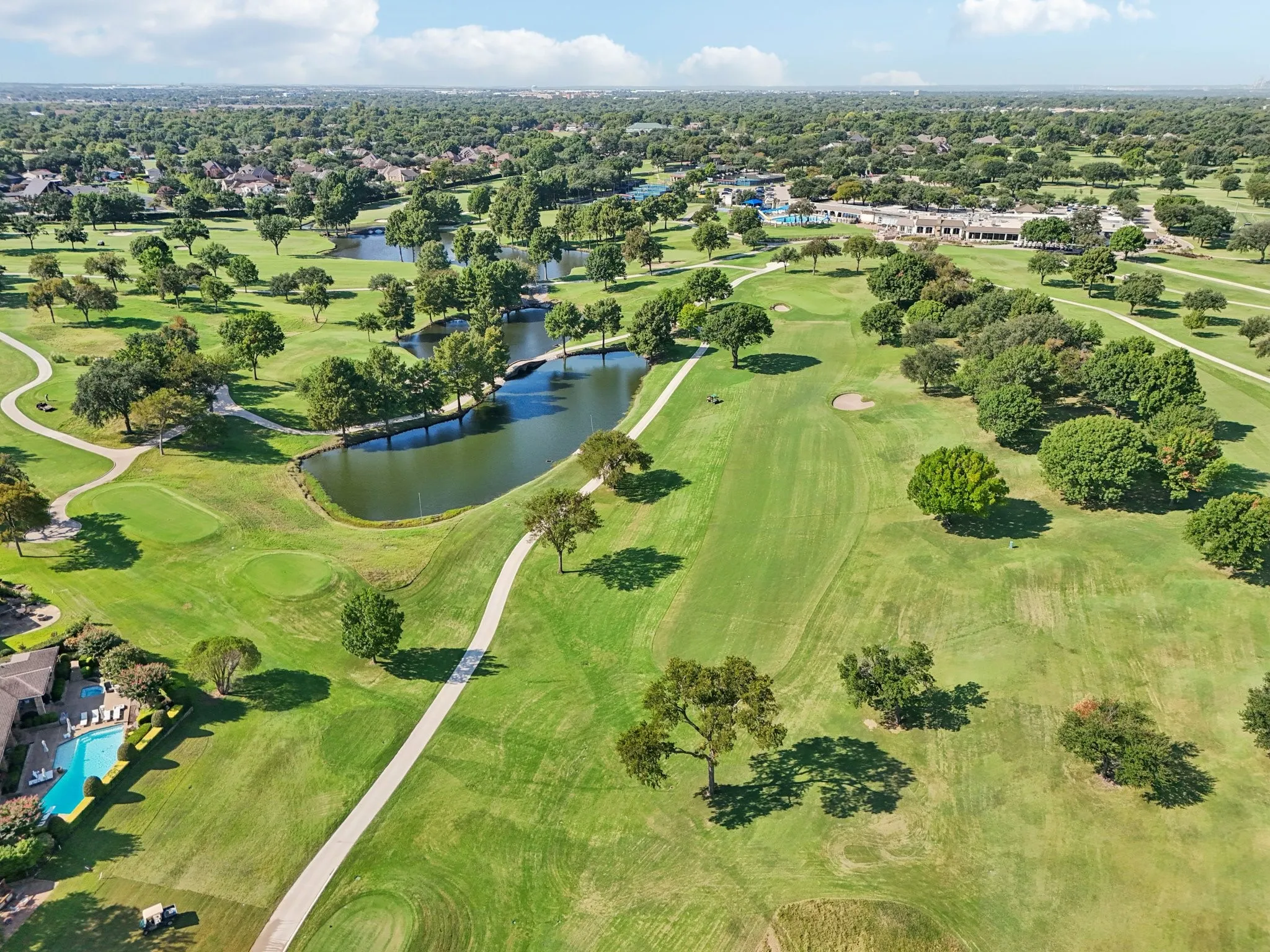 Expansive golf course landscape featuring lush green fairways and mature trees