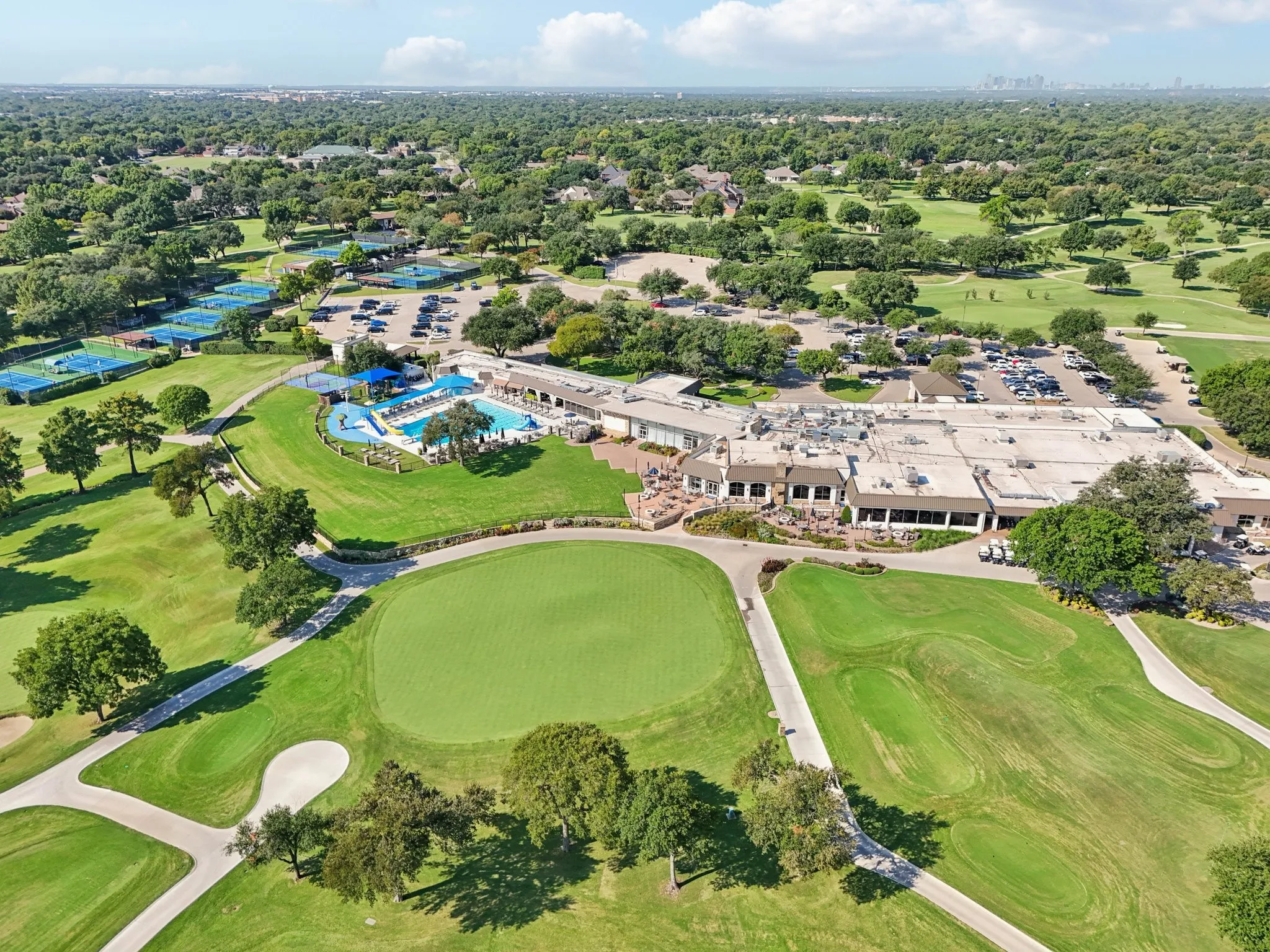 Expansive golf course featuring a green, sand traps, and cart paths
