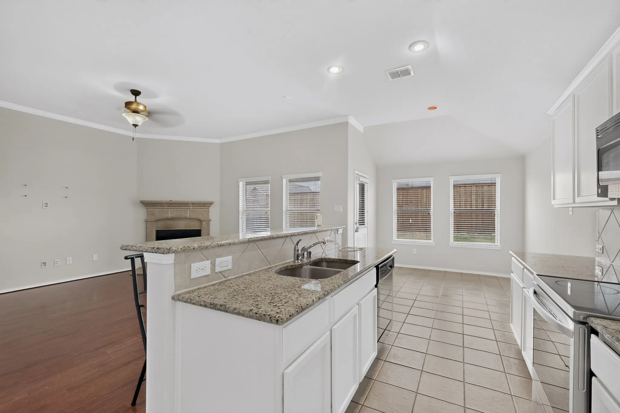 Kitchen featuring white cabinetry, stainless steel sink, and granite countertops