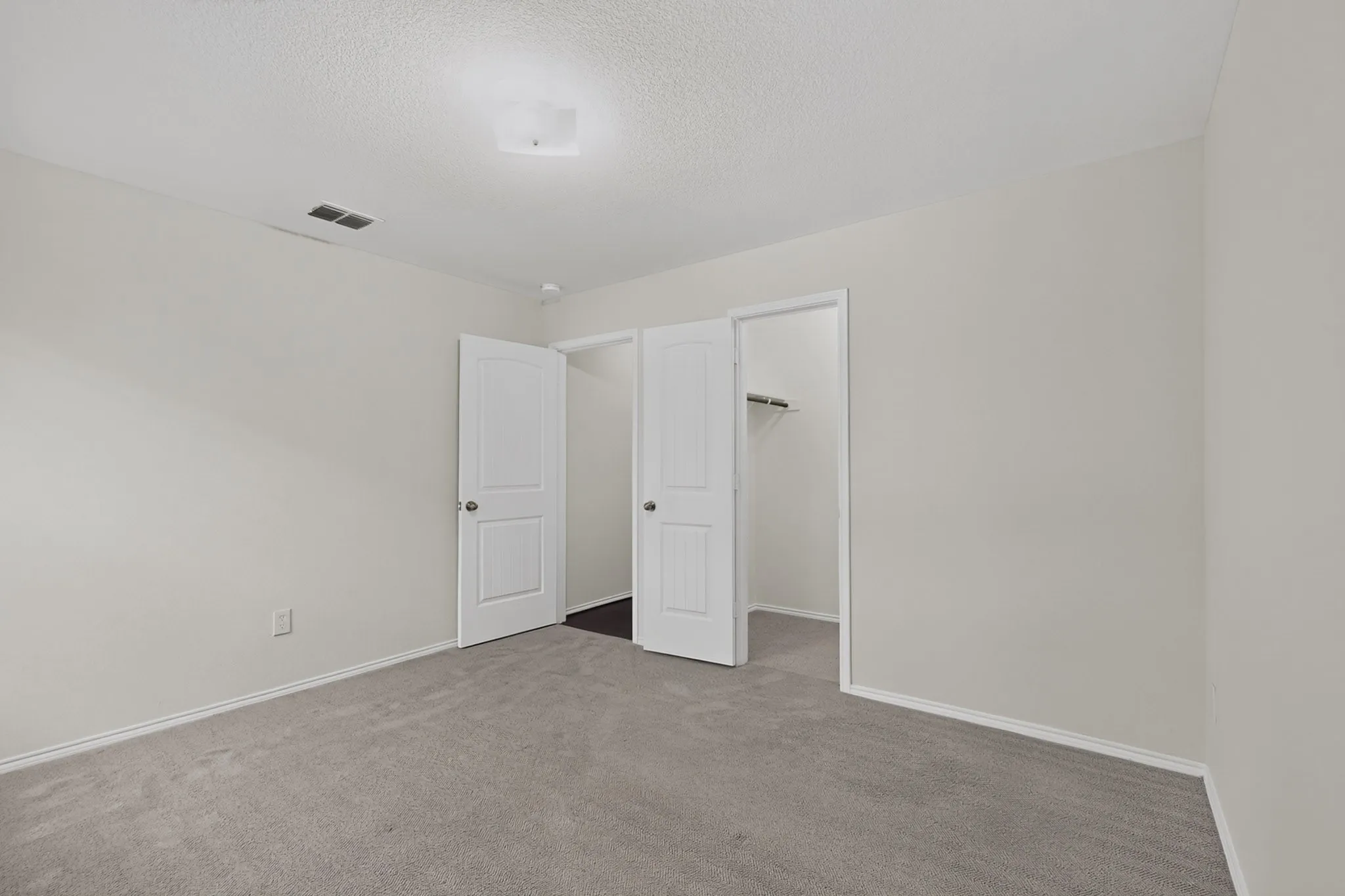 Neutral wall color, wall-to-wall carpeting, overhead lighting, and white trim