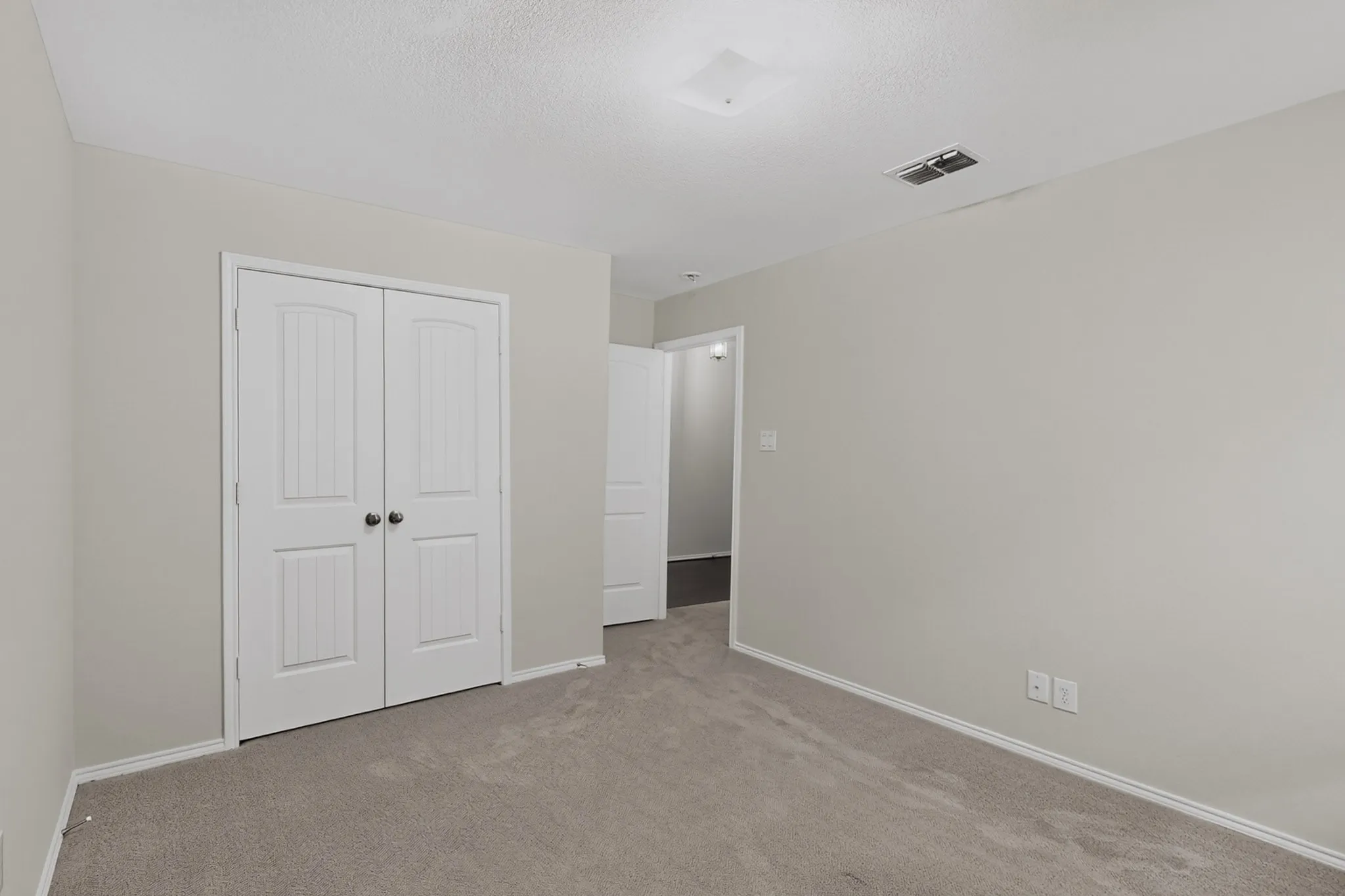 Neutral-toned walls complement plush carpet flooring