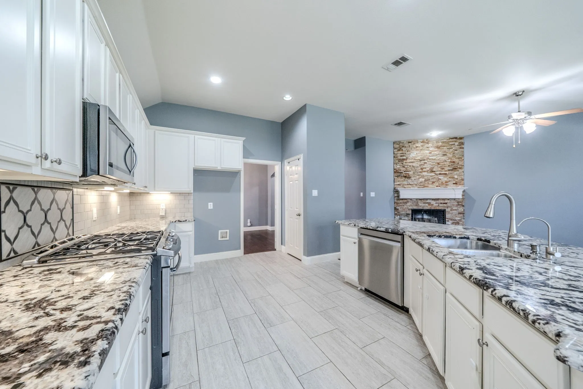 Kitchen featuring light wood-finish plank flooring and white cabinetry