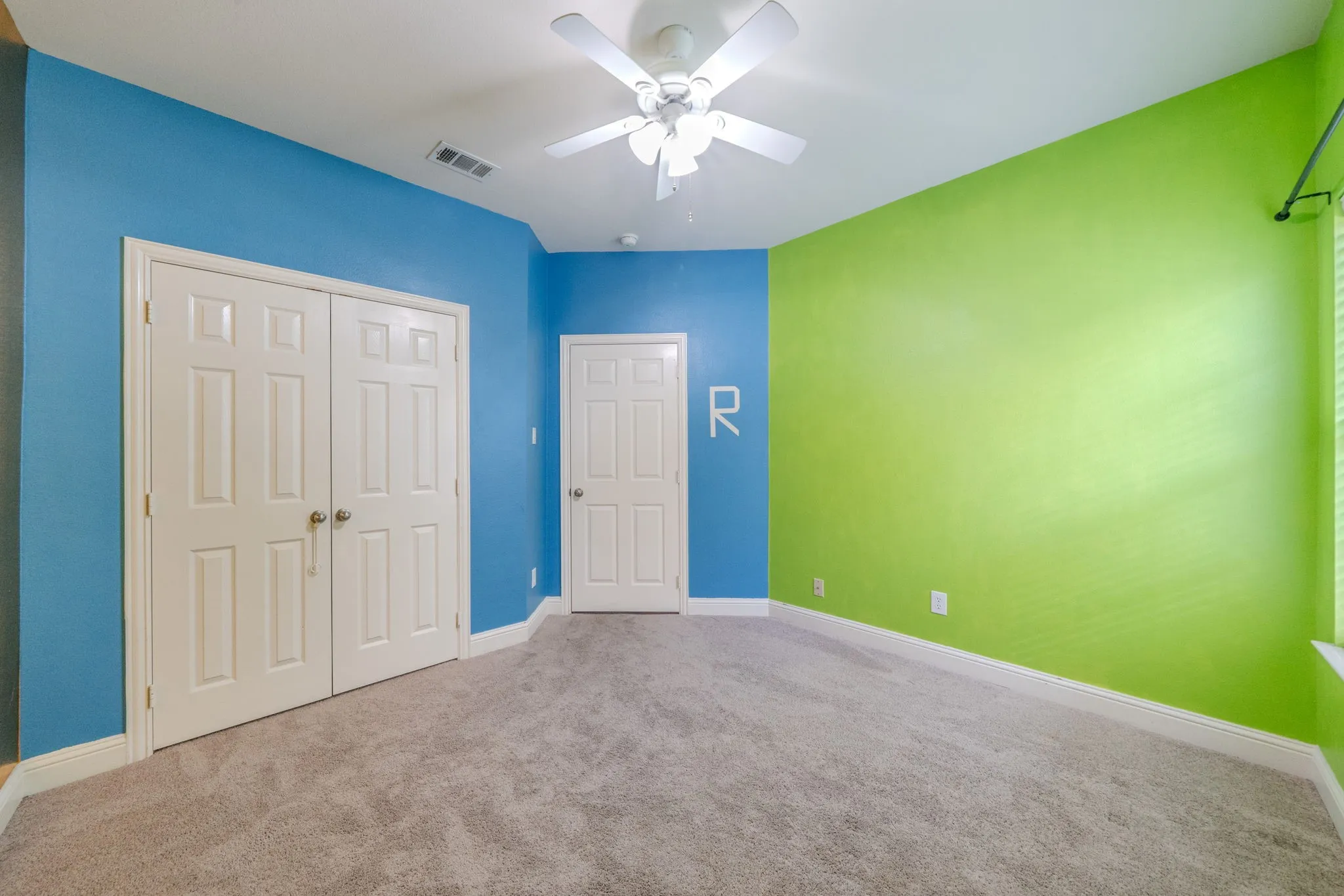 Interior room featuring gray carpet flooring, a ceiling fan, and white baseboards