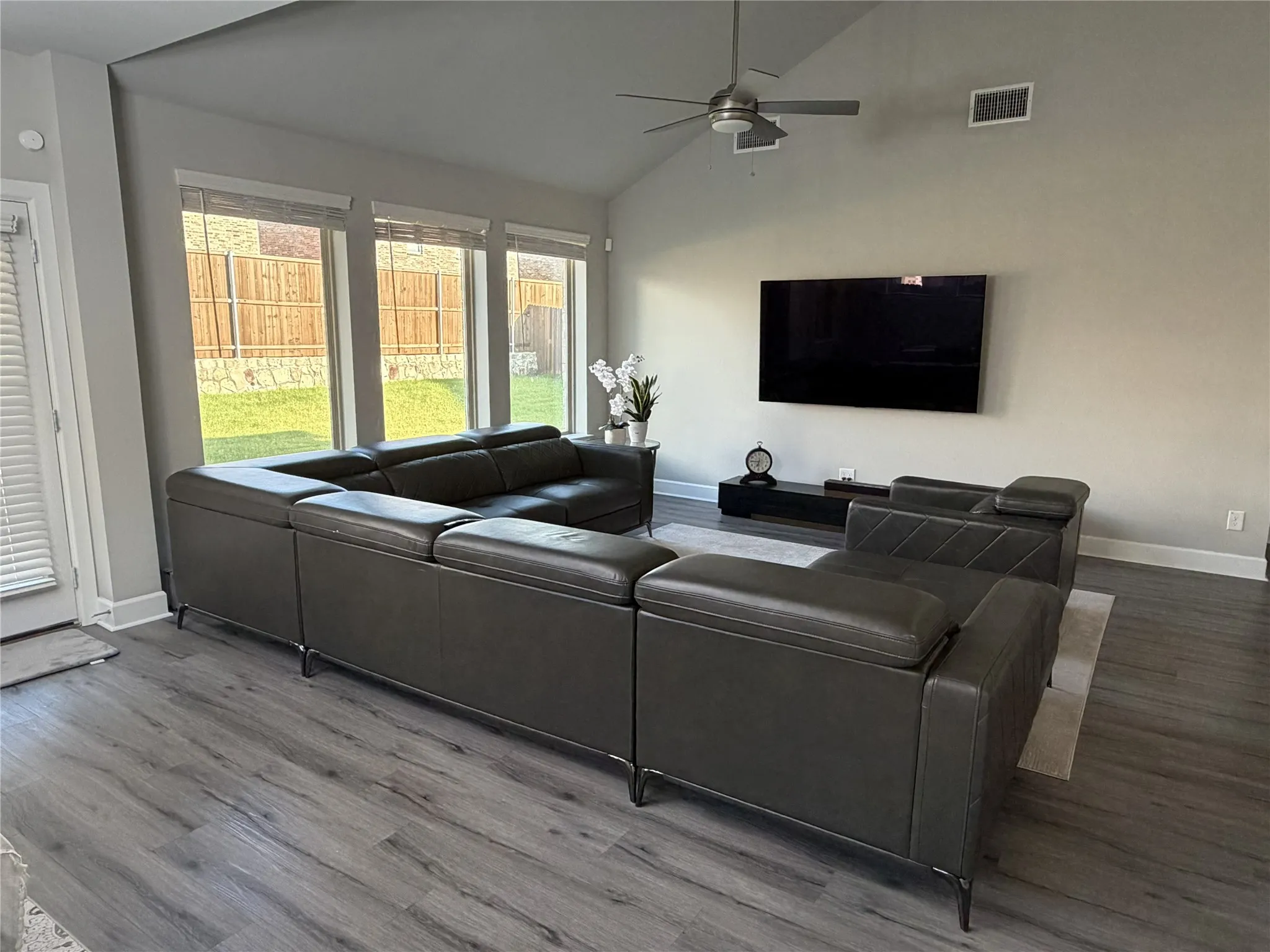 Living area featuring a vaulted ceiling with a flush-mount ceiling fan