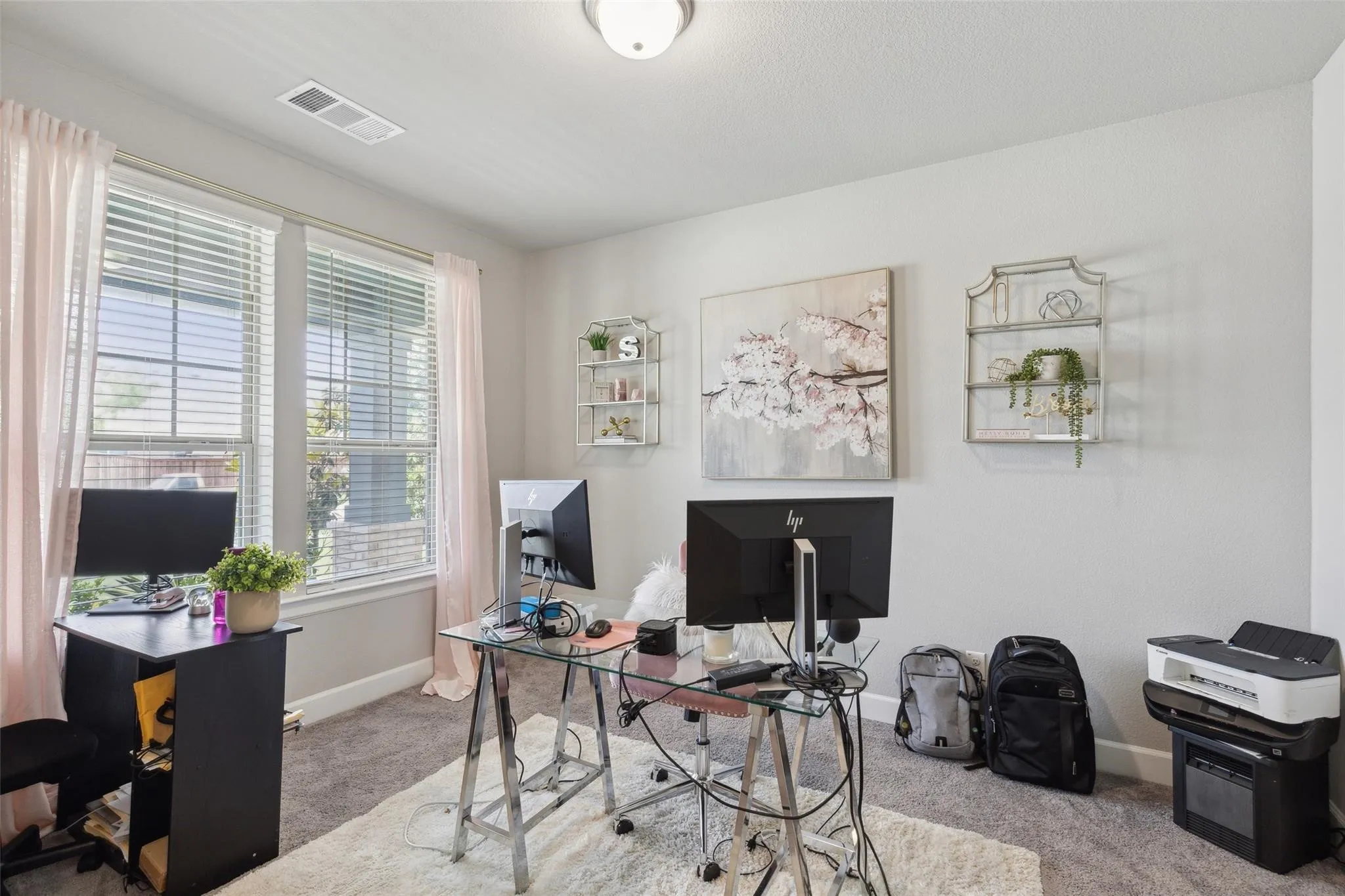 Carpeted room featuring multiple windows with blinds, a flush mount ceiling light, and light-colored walls