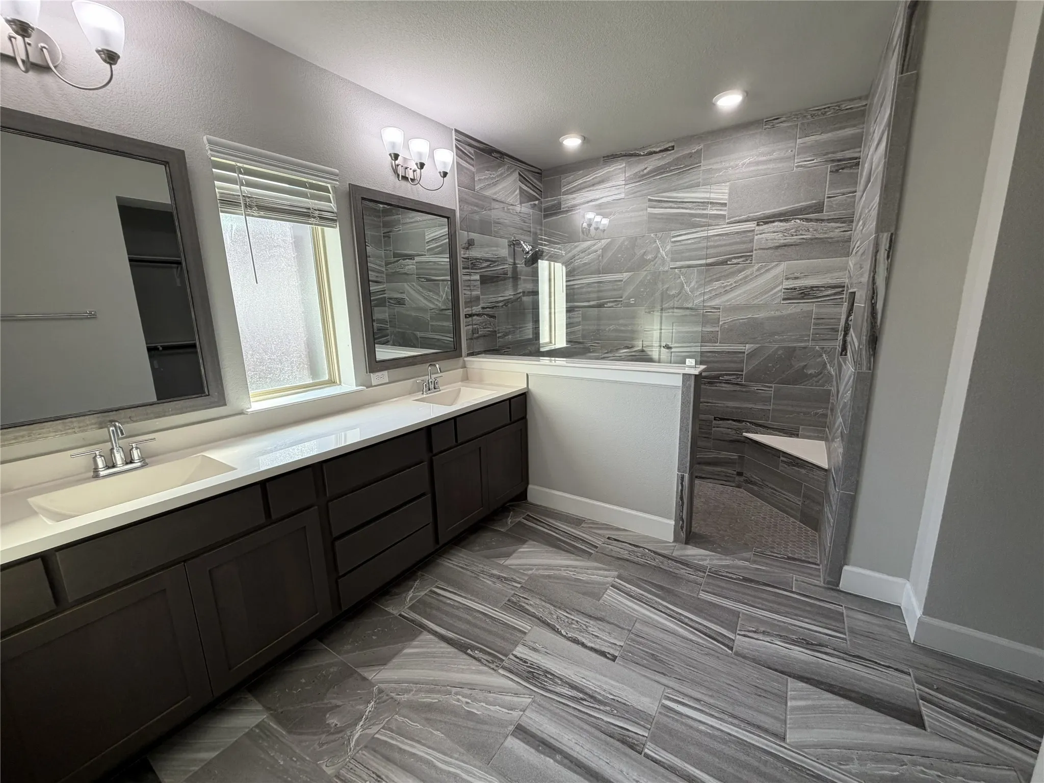 1st Floor Primary Bathroom Spacious bathroom featuring a dual vanity with rectangular undermount sinks, dark wood cabinetry, and light-toned countertops
