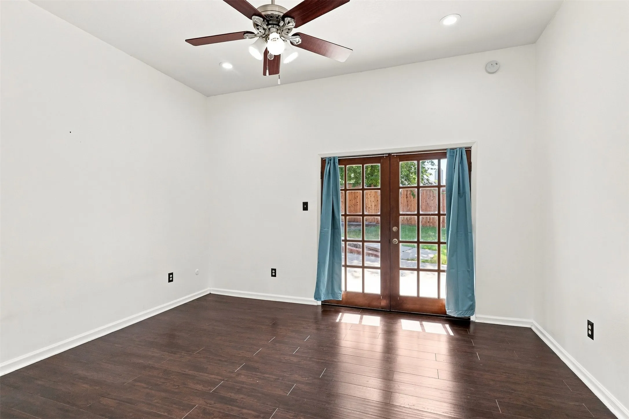 Wood-finish flooring with white walls and recessed lighting