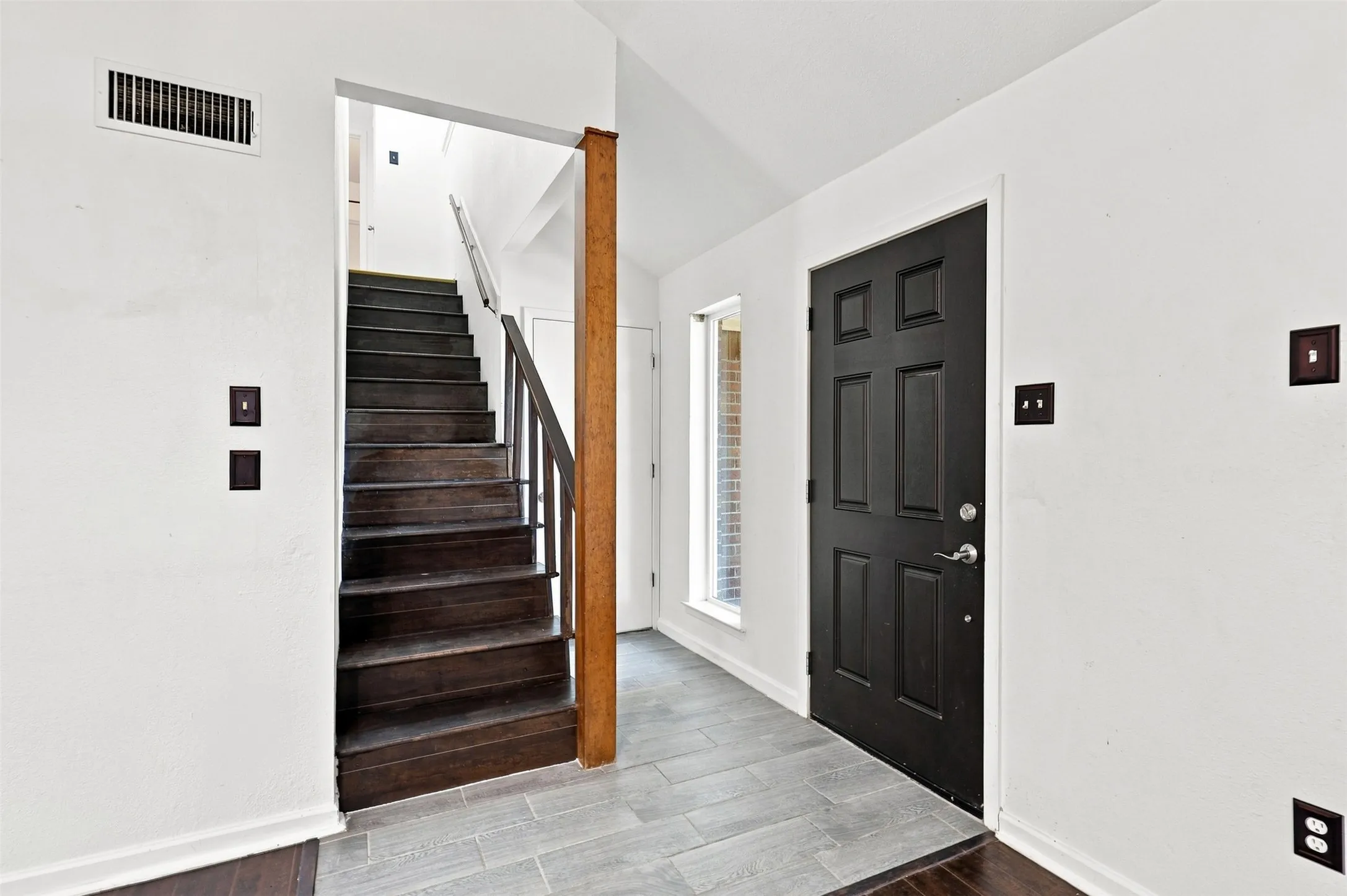 Wood staircase with dark risers and banister