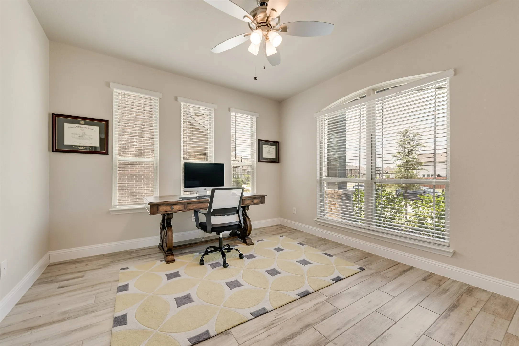 Room featuring wood-finish flooring, a ceiling fan with integrated lighting, and light-toned walls