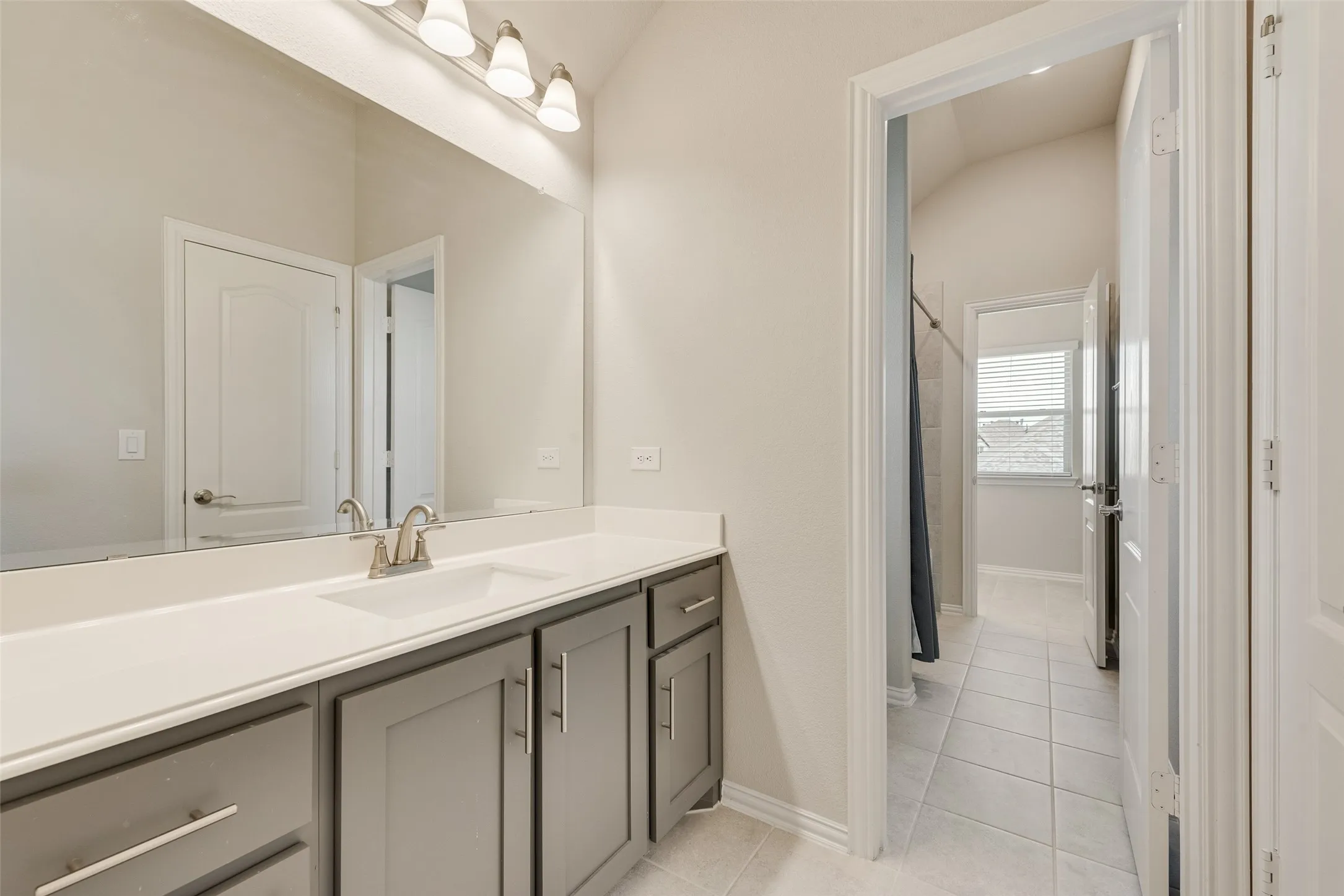 Double vanity with gray cabinetry and brushed nickel hardware