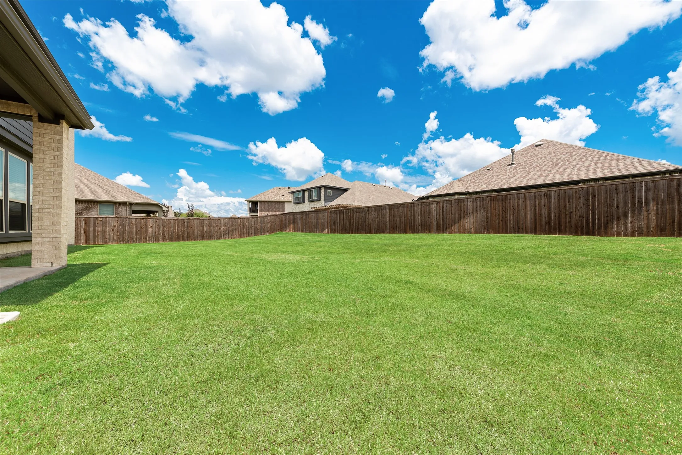 Expansive green lawn with a wood privacy fence