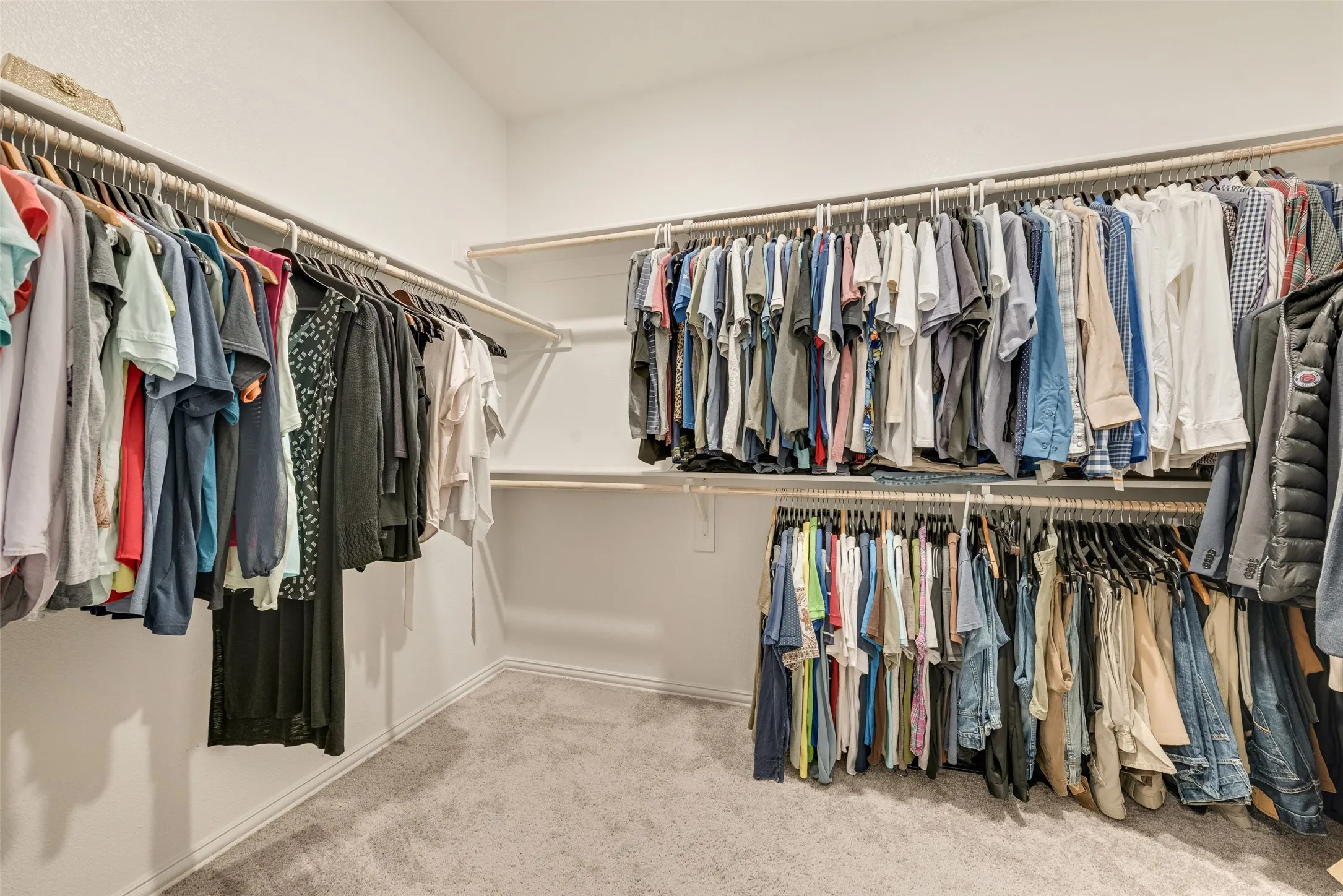 Spacious walk-in closet featuring extensive built-in shelving and hanging rods