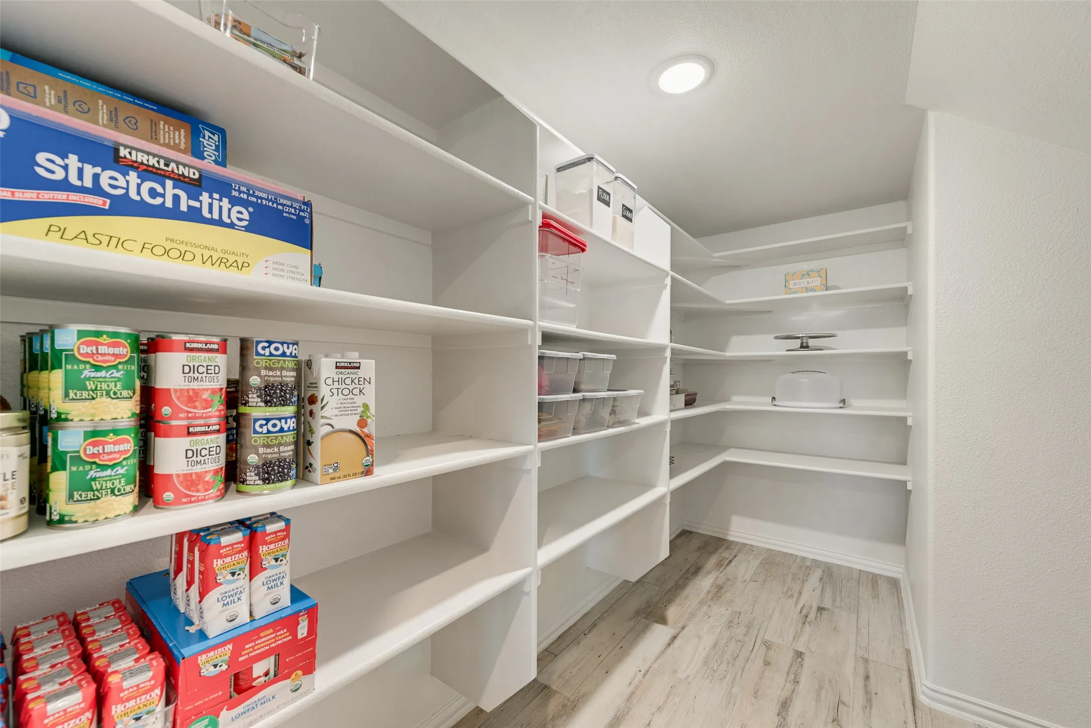 Spacious walk-in pantry featuring extensive white shelving