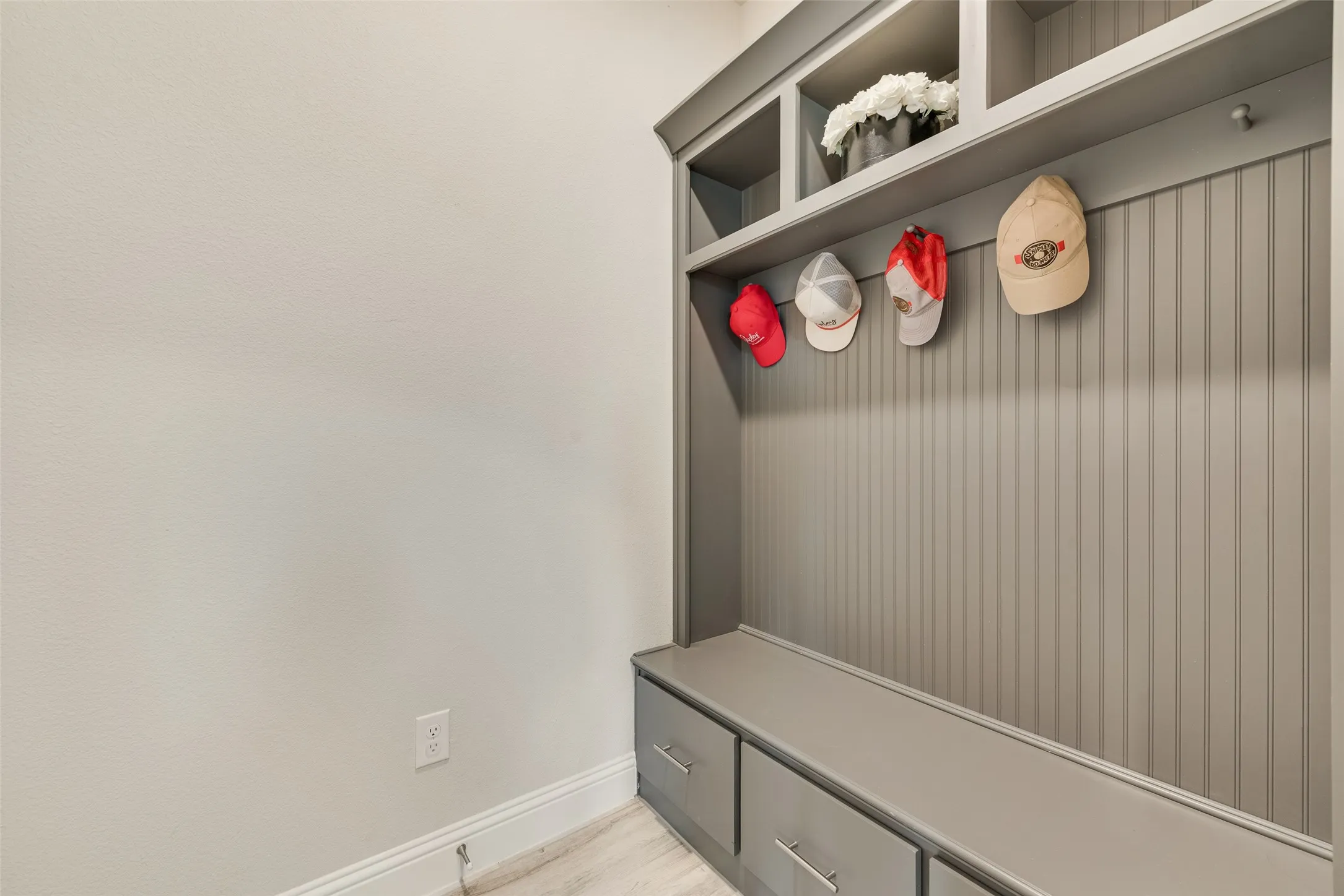 Custom built-in storage unit with beadboard backing, integrated shelving, and lower drawers