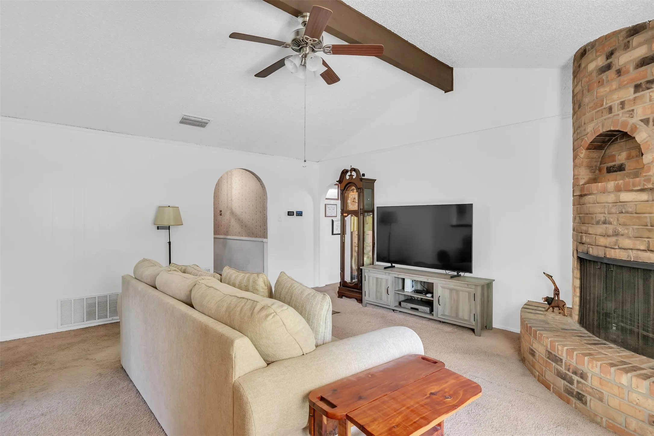 Vaulted ceilings with exposed wood beams and a ceiling fan