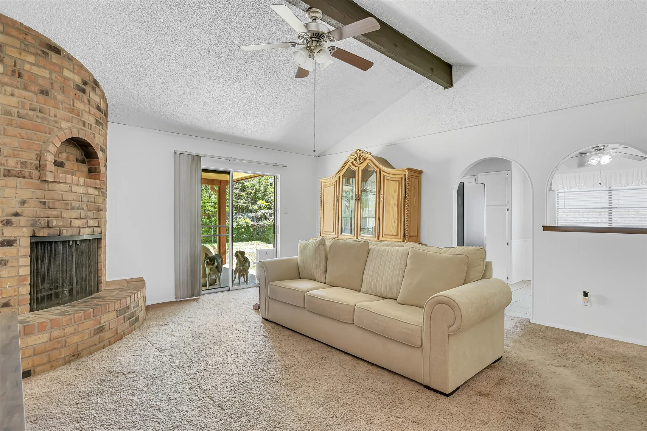 Vaulted ceiling with exposed wood beam and ceiling fan