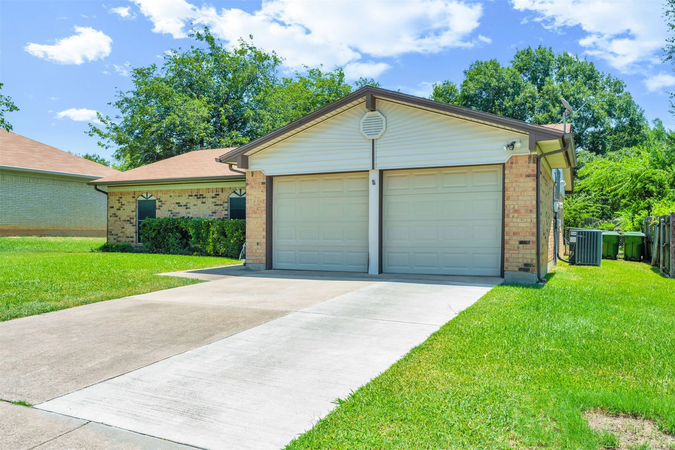 Brick exterior with a brown shingle roof, featuring a two-car garage and a concrete driveway