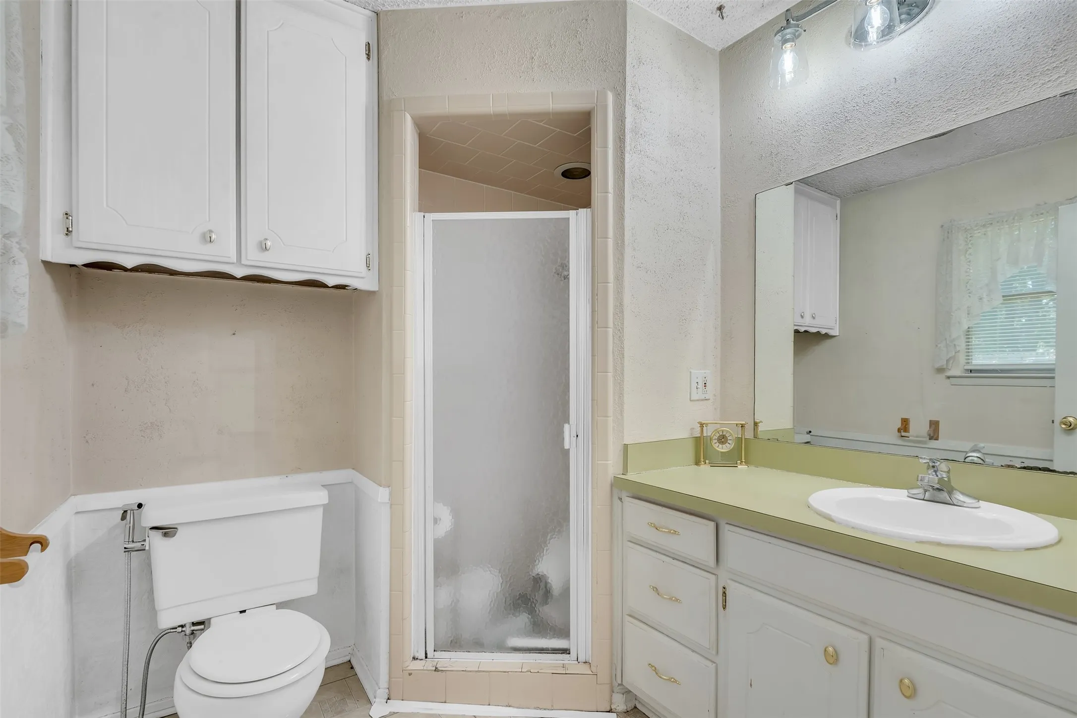Bathroom featuring a white vanity with a light green countertop and an integrated sink