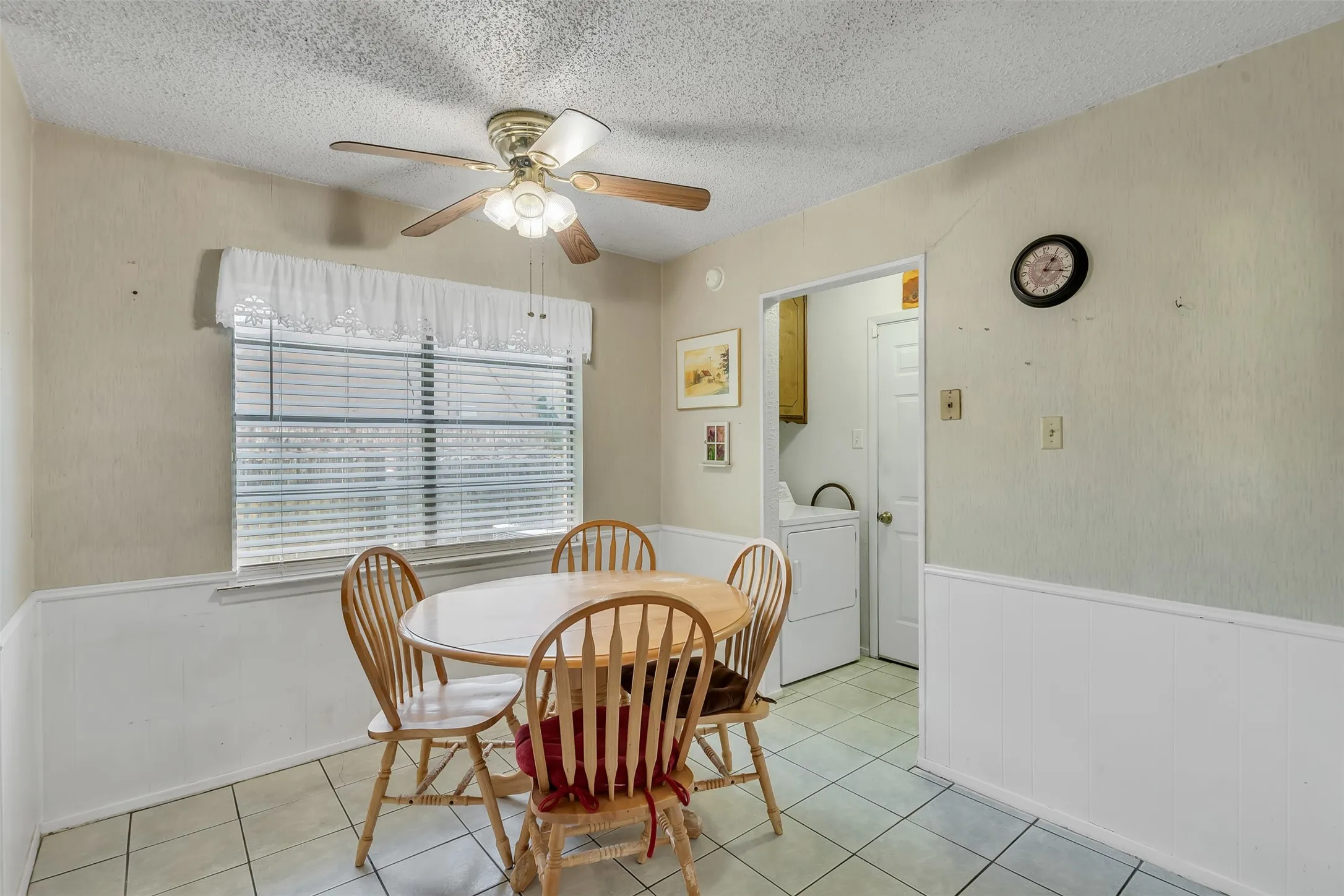 Dining area featuring tiled flooring, wainscoting, and a ceiling​​‌​​​​‌​​‌‌​‌‌​​​‌‌​‌​‌​‌​​​‌​​ fan