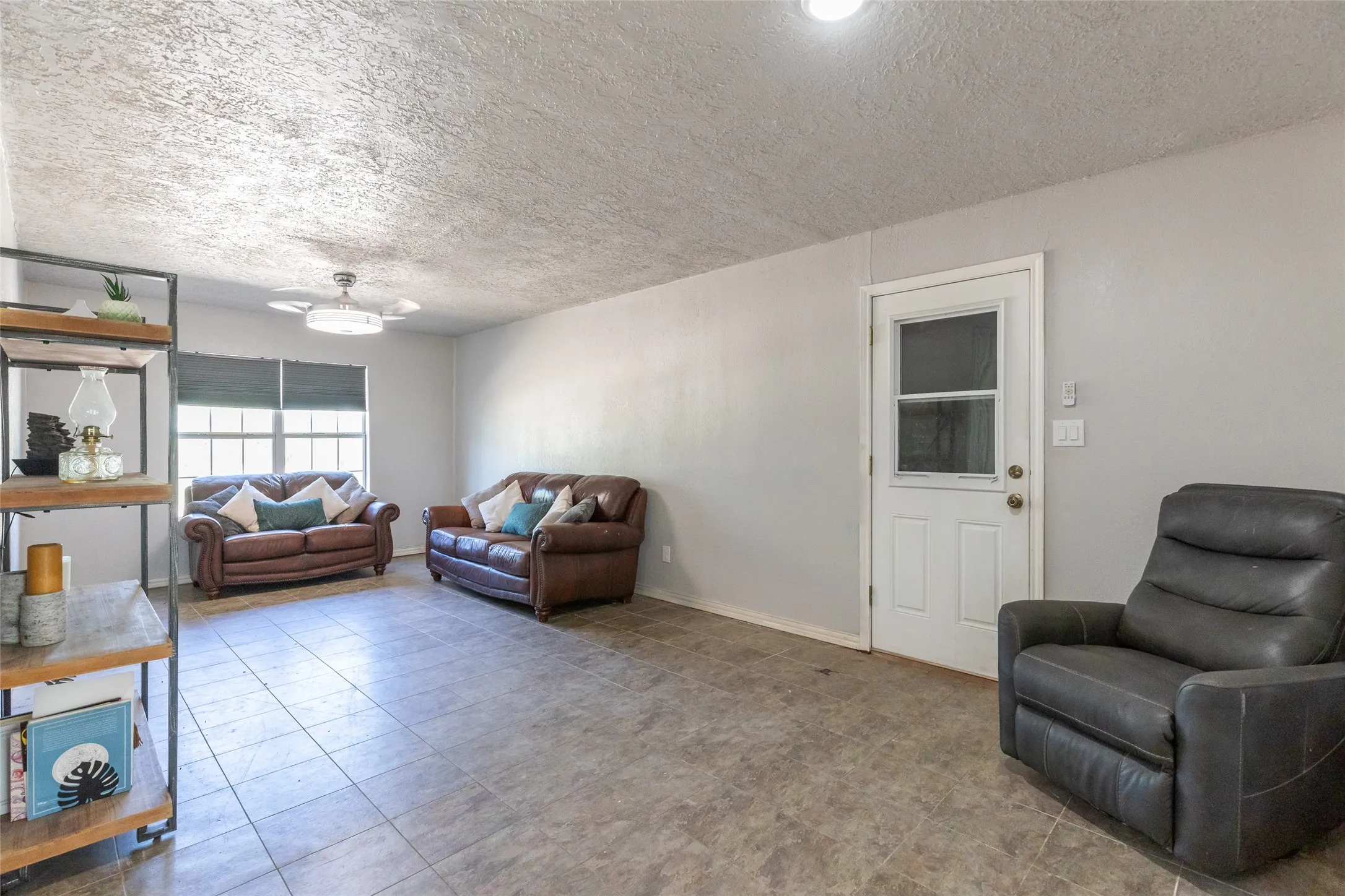 Open-concept living area with tile flooring and light gray walls