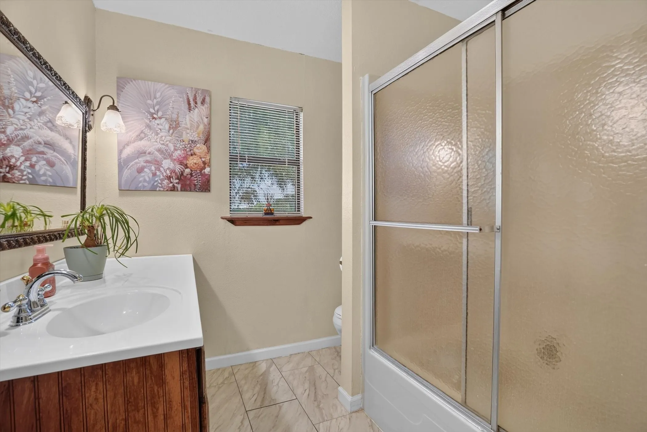 Bathroom featuring a vanity with a white countertop and wood-paneled base