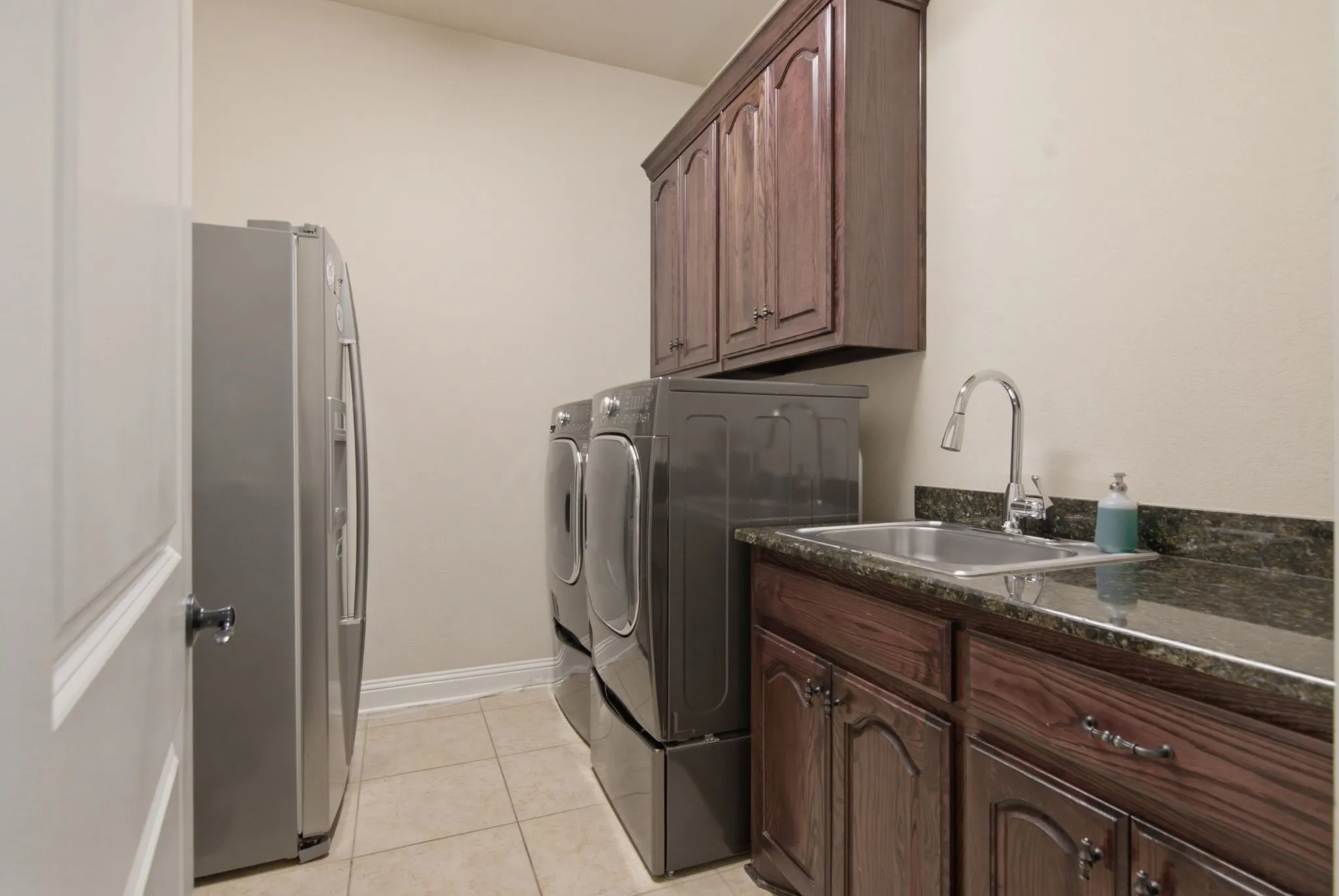 Fantastic laundry room with room for a second refrigerator. Granite counters, sink, and built in cabinets.