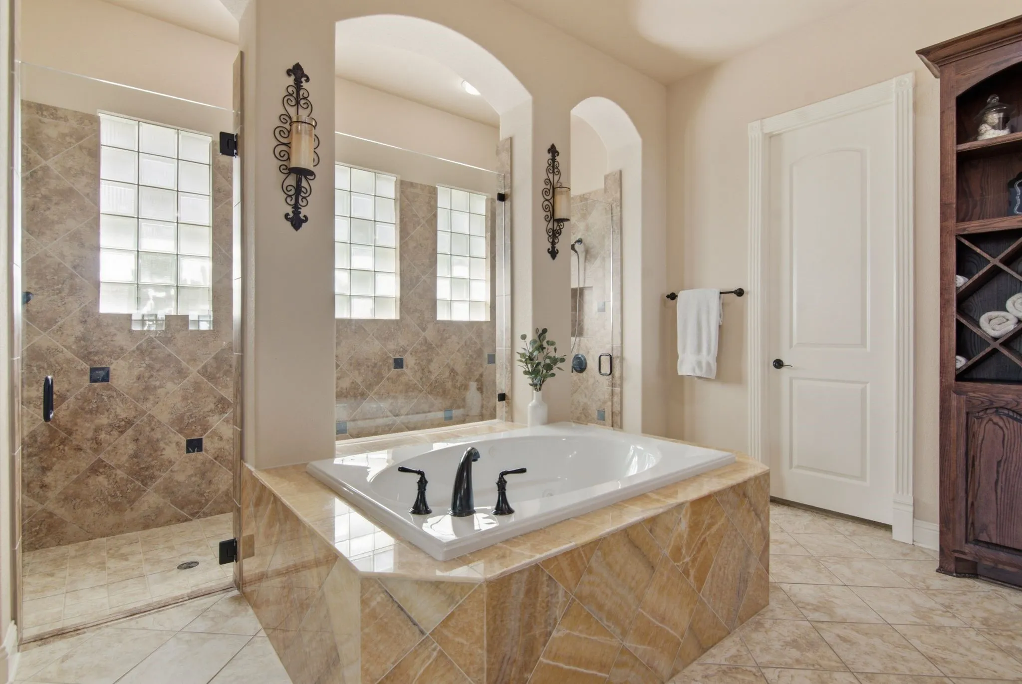Spa inspired primary bath with oversized dual shower and jetted tub.