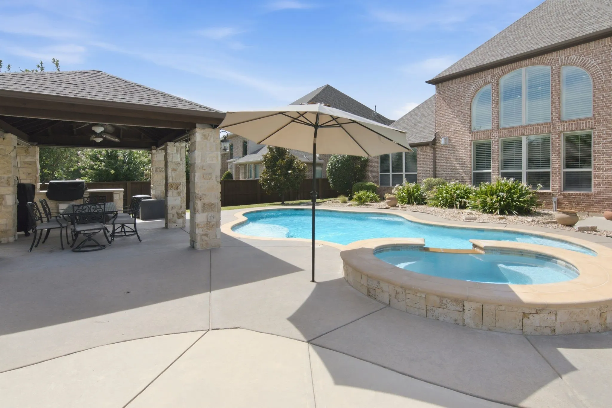Large covered patio, with built in grill, storage, and ceiling fans.