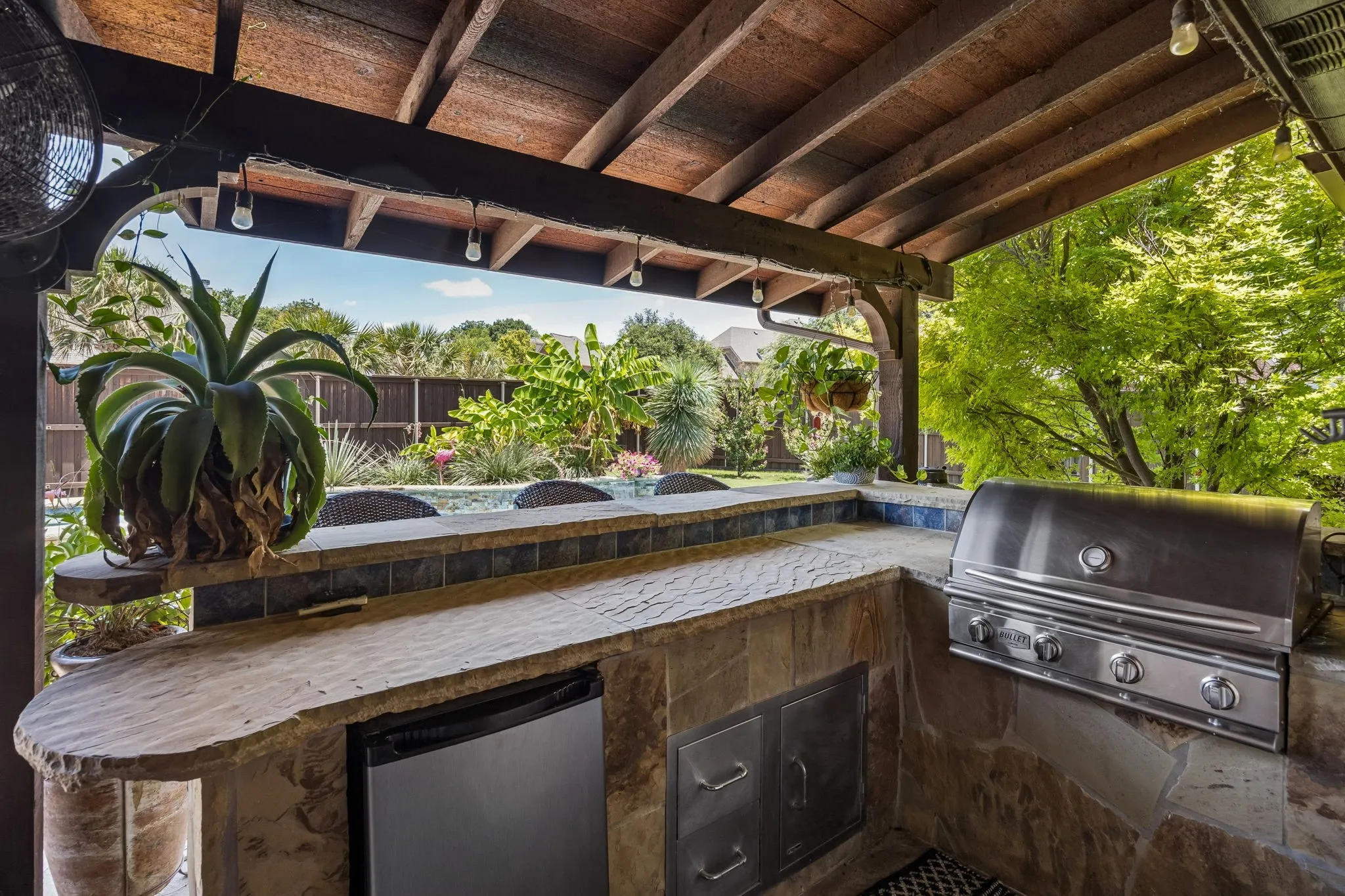 Built in gas grill and refrigerator with bar seating, this outdoor kitchen levels up your outdoor living.