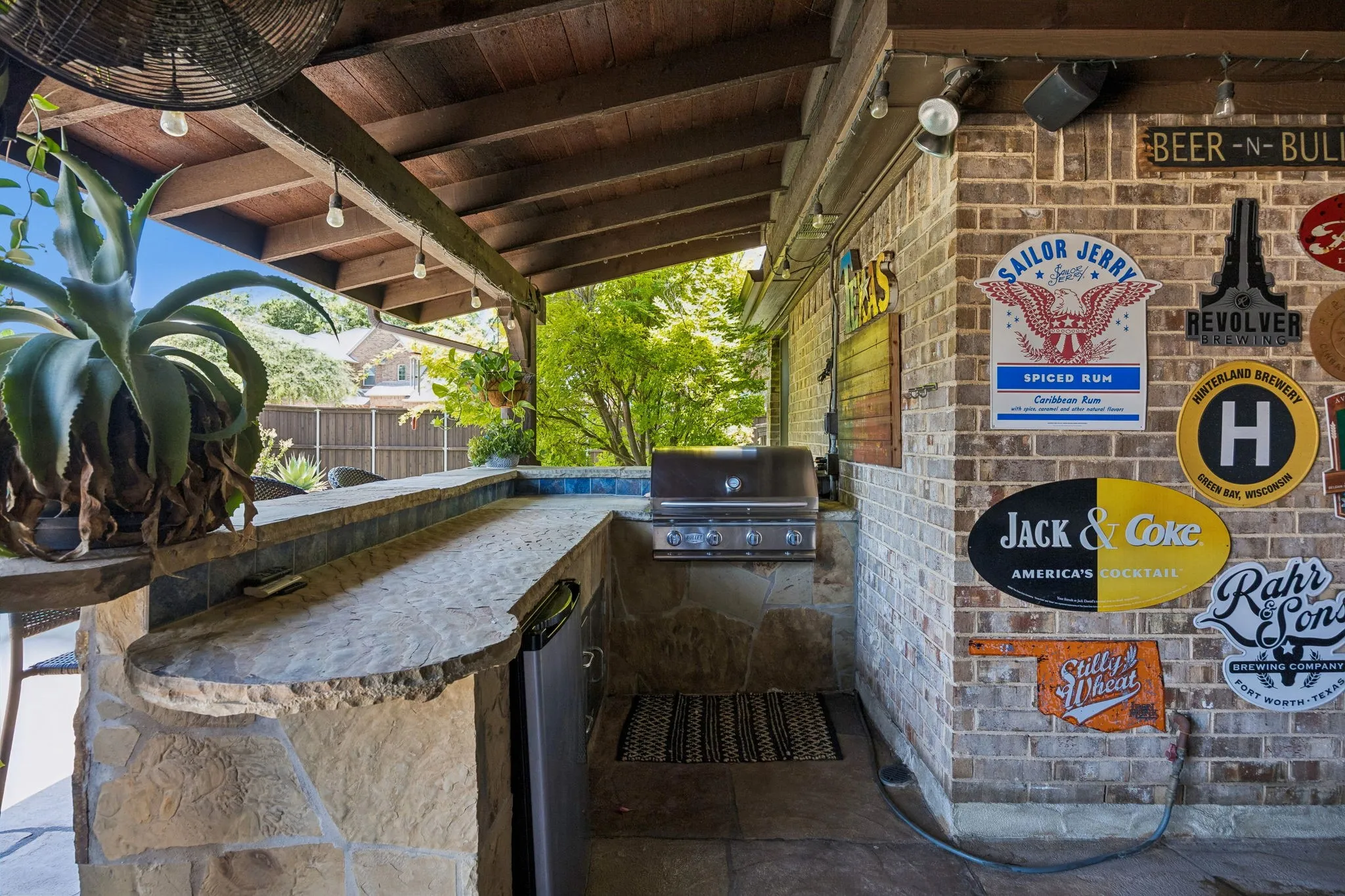 Built in gas grill and refrigerator with bar seating, this outdoor kitchen levels up your outdoor living.