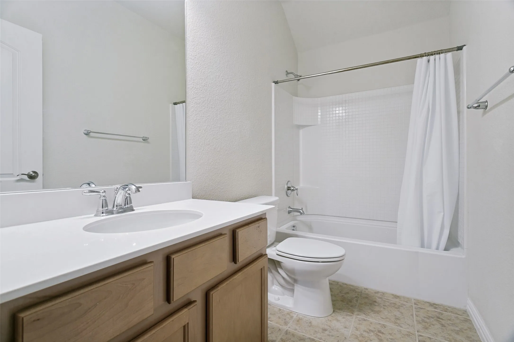 Bathroom featuring a white vanity with an integrated sink, chrome faucet, and wood-finish cabinetry