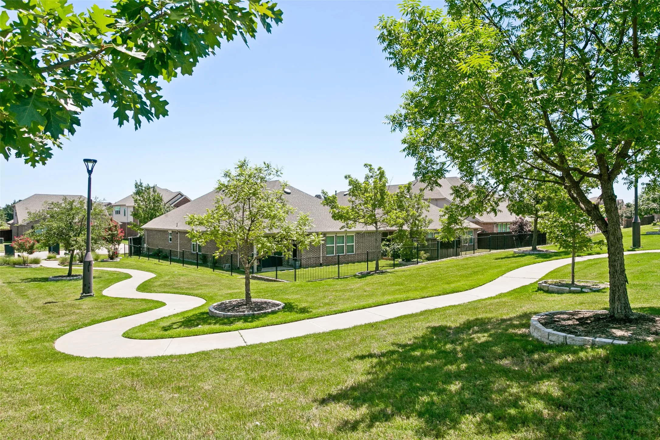 Expansive green space featuring a winding concrete pathway