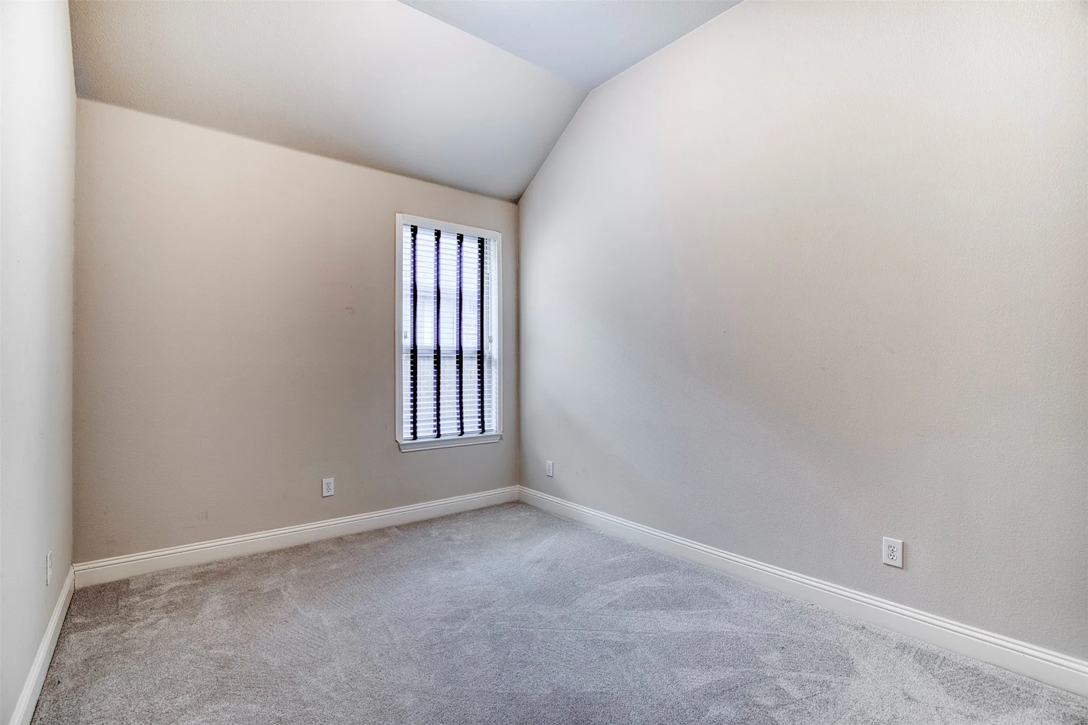 Secondary bedroom with vaulted ceiling.