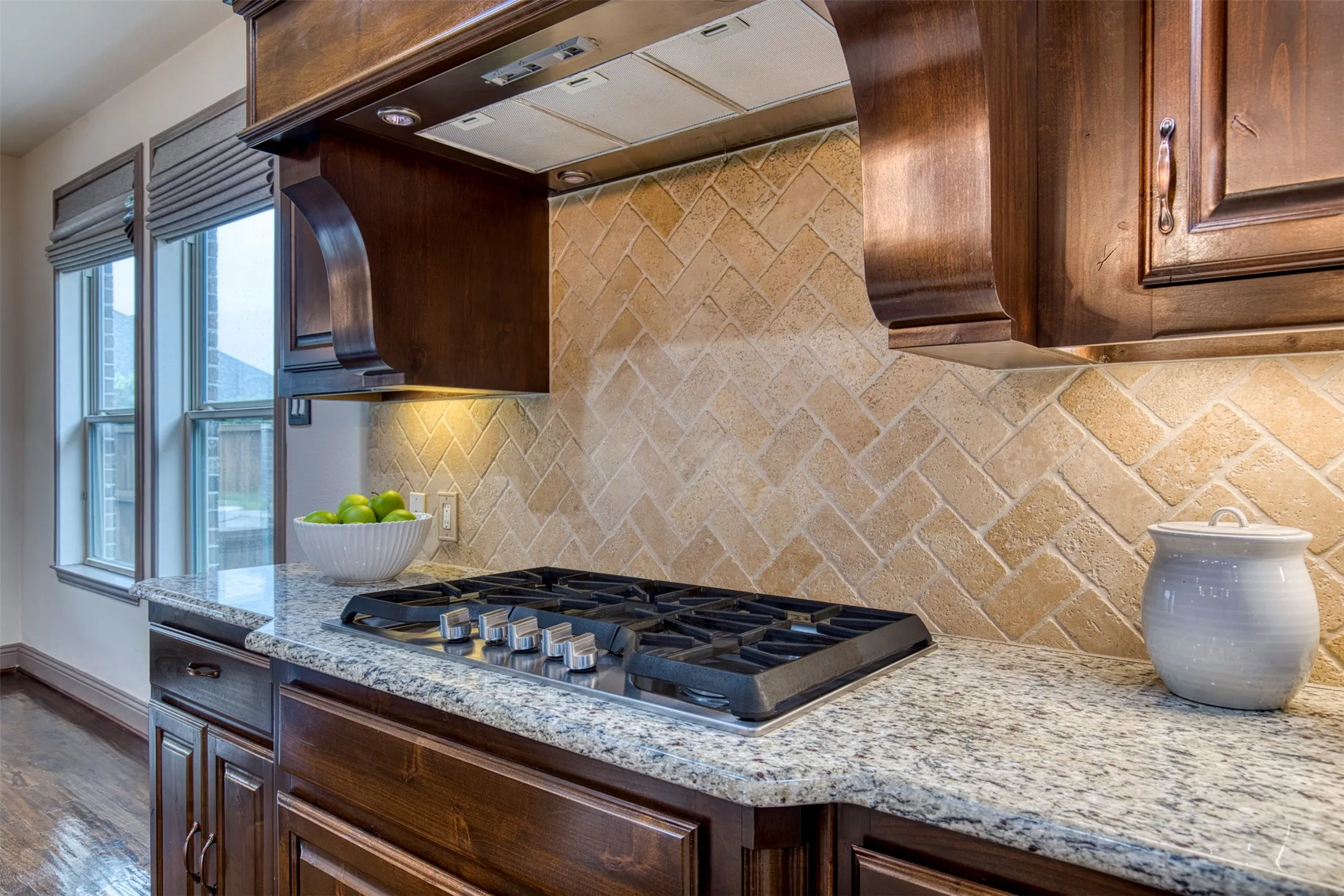 Kitchen with under cabinet lighting and gas cooktop.