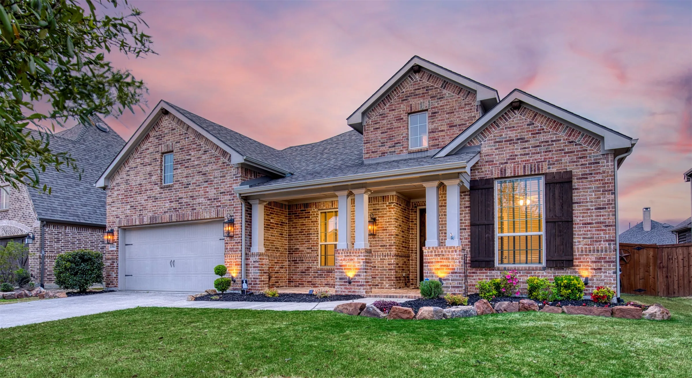 Oversized 2 car garage, lush landscaping, and cozy front porch welcome you inside.