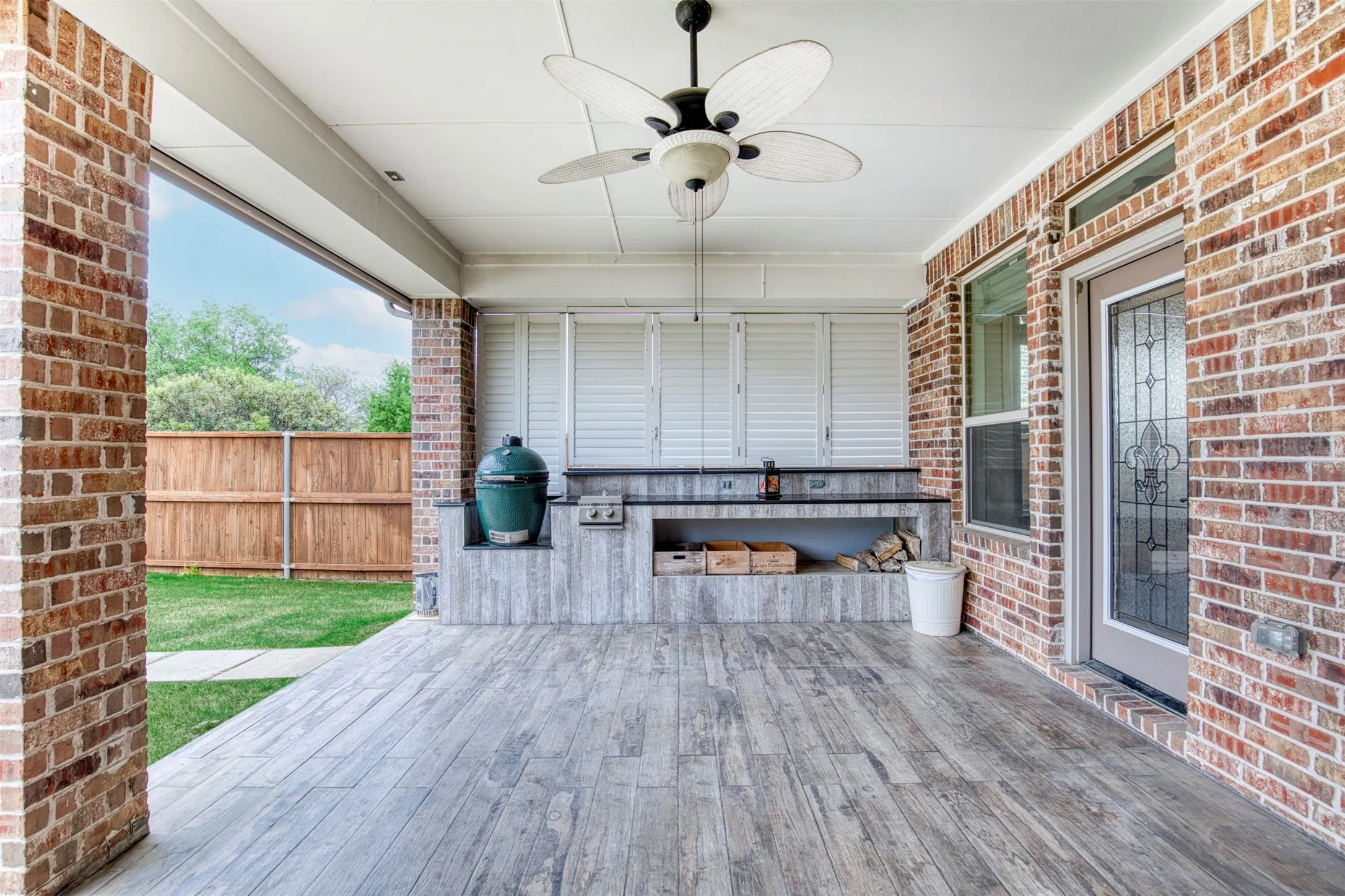 Patio with outdoor kitchen with shutters.