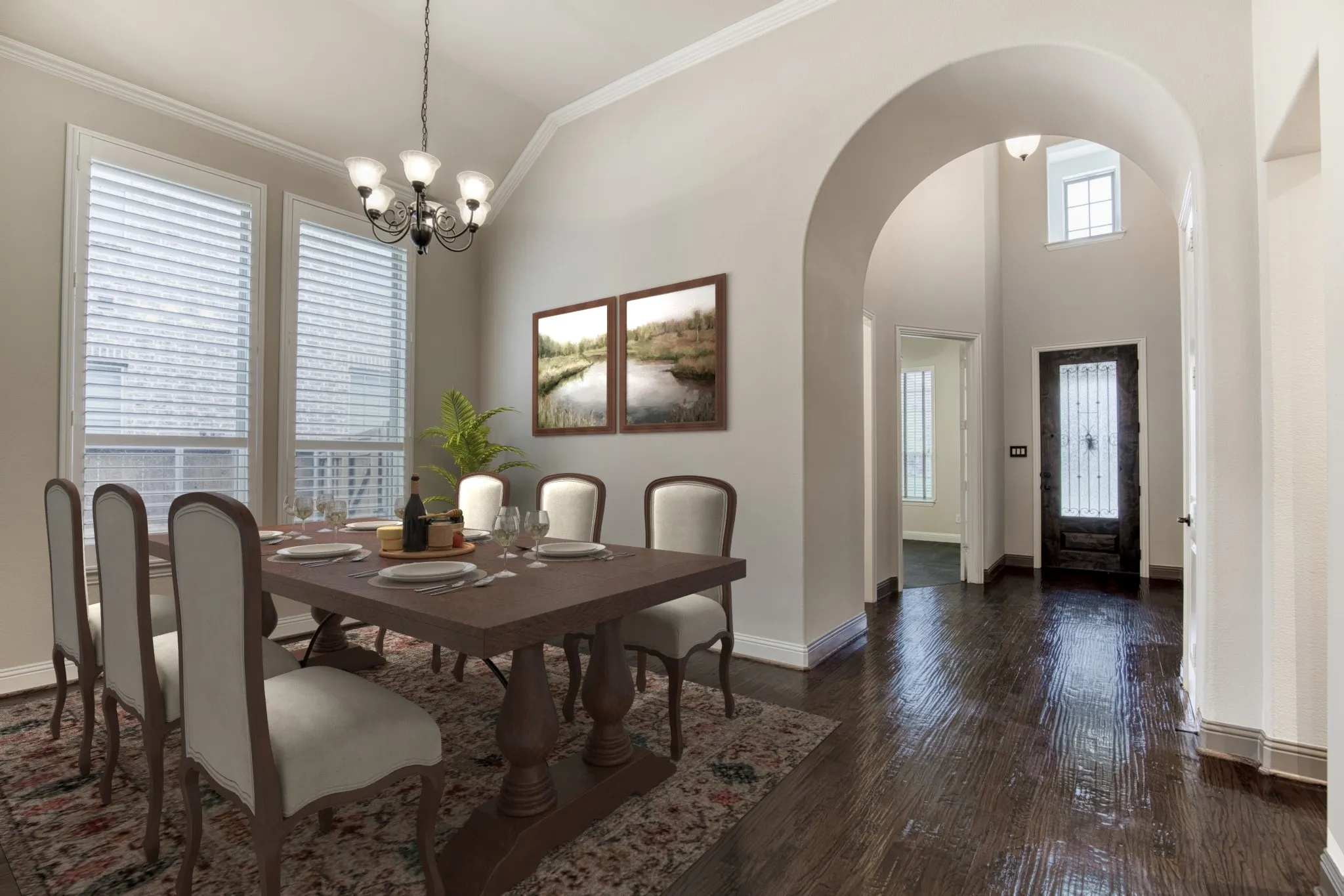 Formal dining room with vaulted ceiling and chandelier.