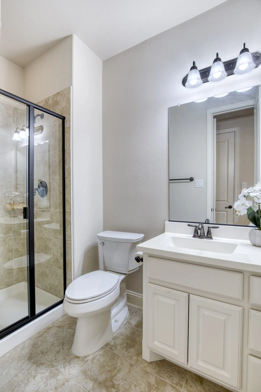 Secondary full bath with framed shower.
