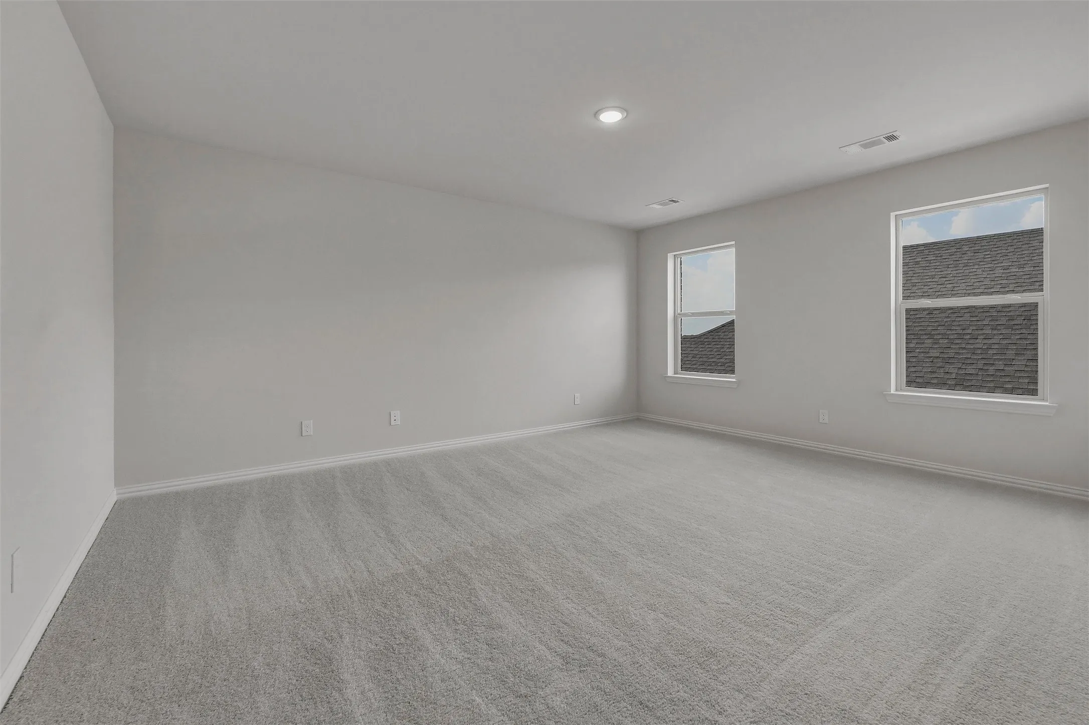 Recessed lighting, light gray carpeting, neutral wall color, white trim, and multiple windows