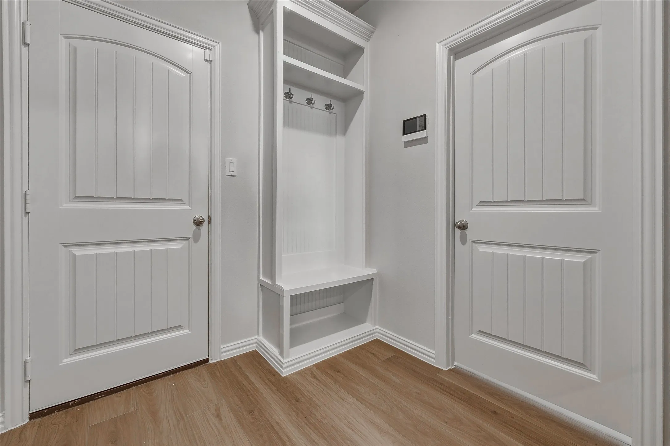 Built-in storage bench with upper shelving and coat hooks