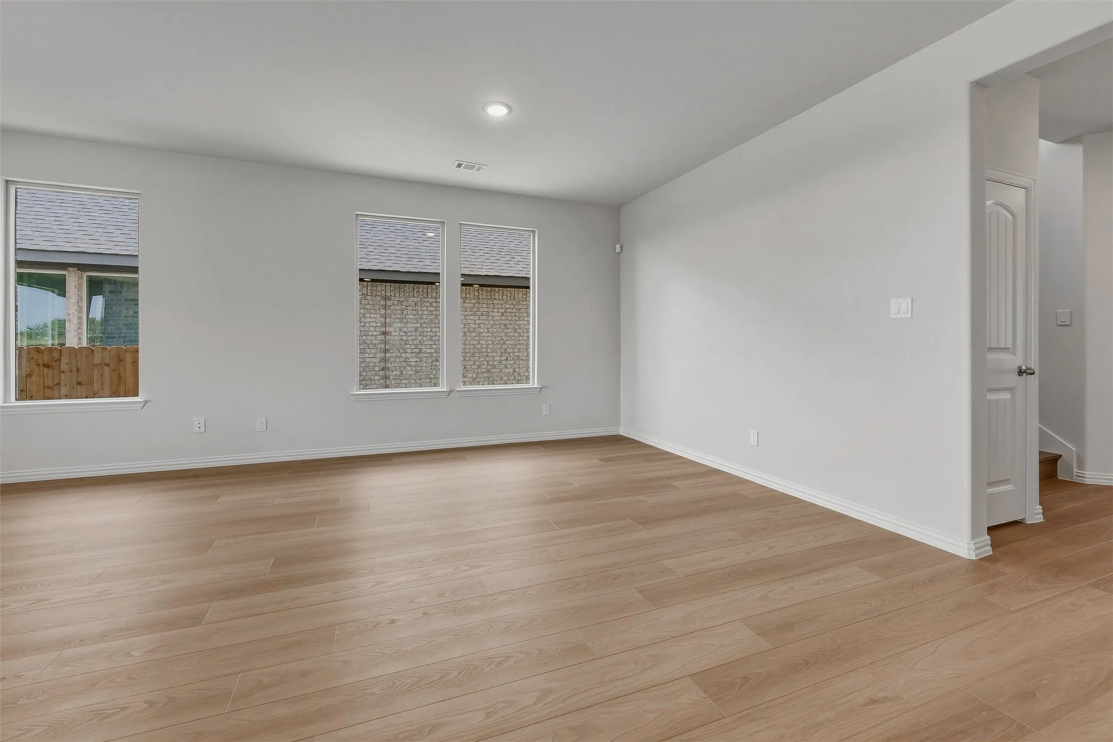 Wood-finish flooring, recessed lighting, and multiple windows