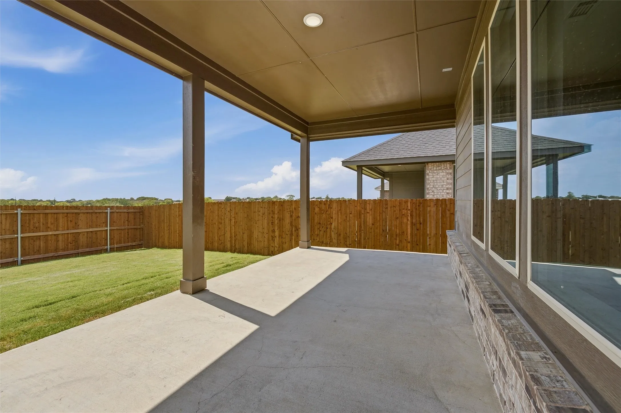Covered patio with concrete flooring, recessed lighting, and a fenced backyard