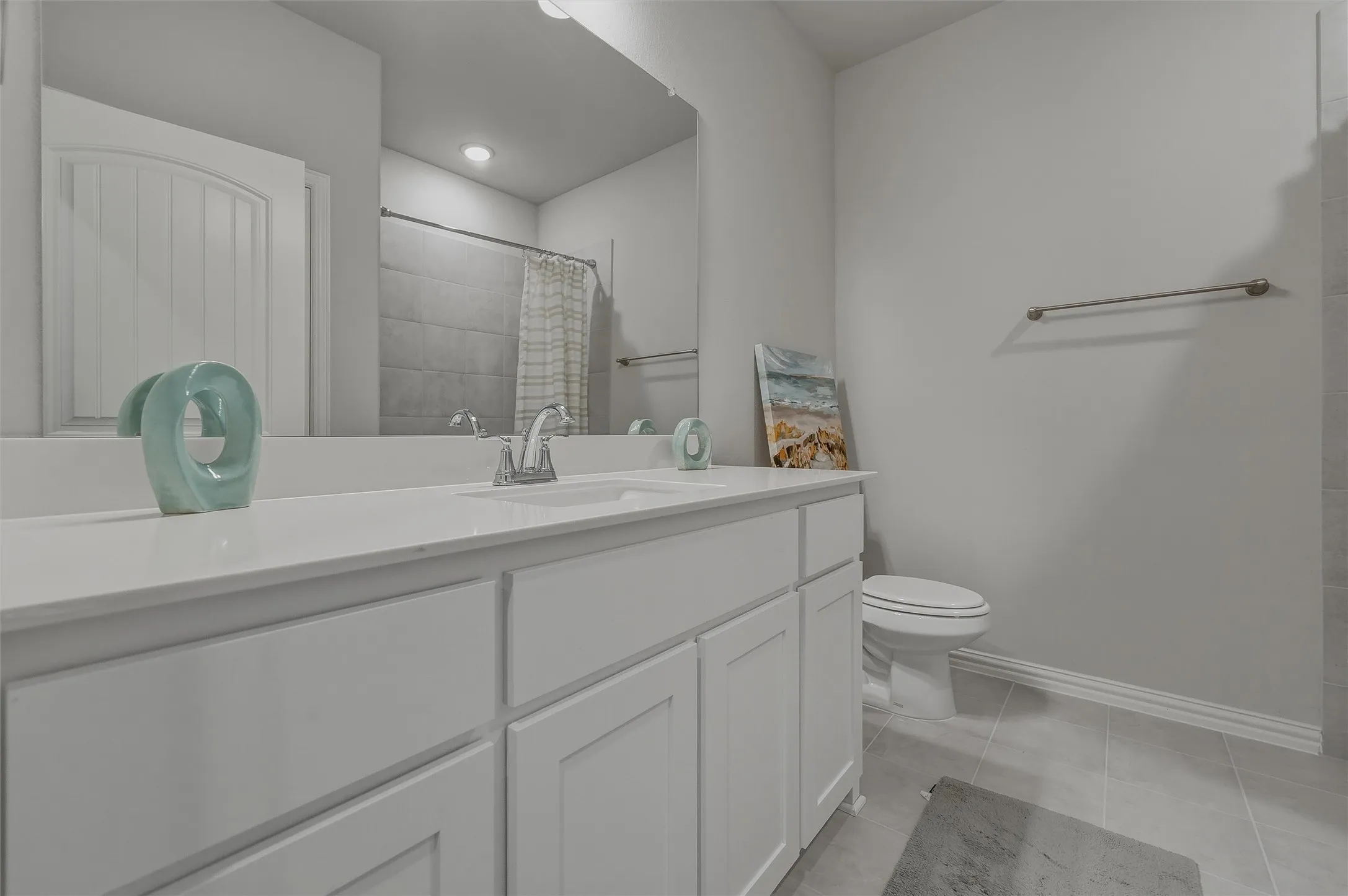 Dual undermount sinks with chrome faucets, white cabinetry, a large vanity mirror, and recessed lighting
