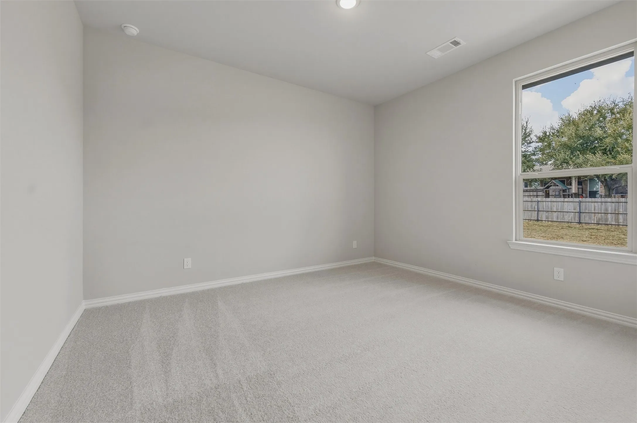Neutral wall tones, recessed ceiling lighting, and light-toned carpeting