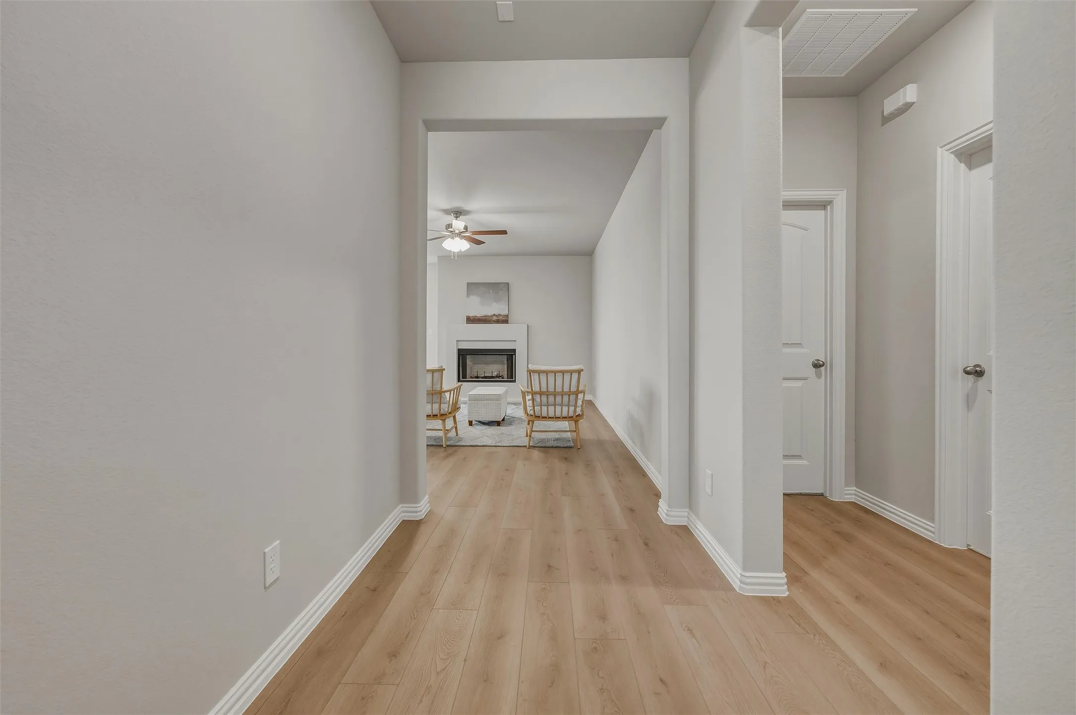 Wood-finish flooring throughout, white trim, and light gray wall finishes